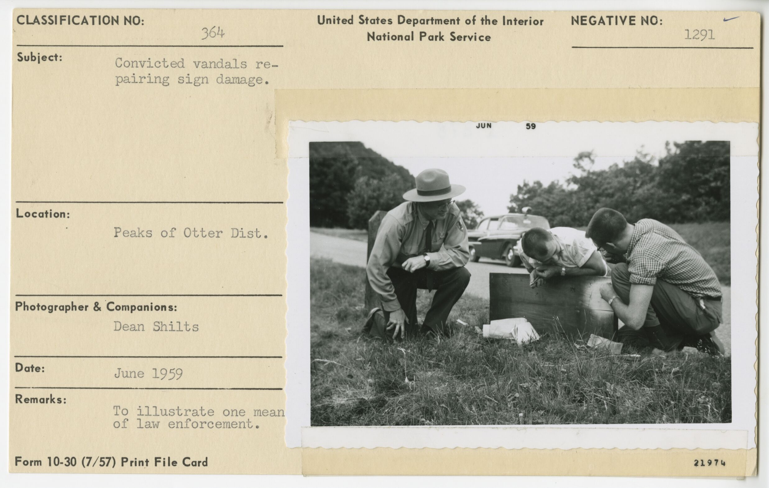 Convicted vandals repairing sign damage with ranger