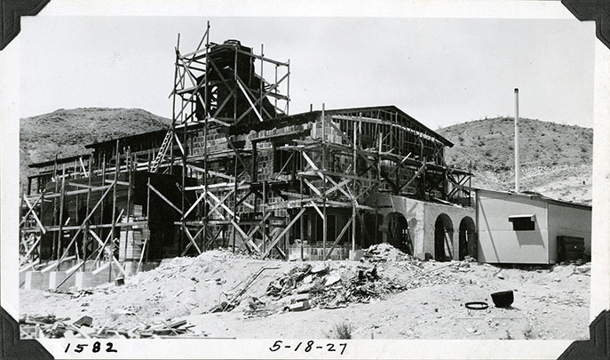 This is an historic black and white photograph from the Scotty's Castle Historic Photograph Collection, Death Valley National Park of Scotty's Castle Main House, looking northwest. Additional scaffold on Observation Tower. Additional hollow tiles on Johnson's Sitting Room south and east walls. May 18, 1927. Photographed by Mat Roy Thompson.