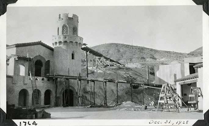 This is an historic black and white photograph from the Scotty's Castle Historic Photograph Collection, Death Valley National Park of Scotty's Castle Annex with construction ramps to Upper Music Room and Observation Tower. December 31, 1928. Photographed by Mat Roy Thompson.