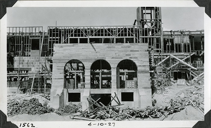 This is an historic black and white photograph from the Scotty's Castle Historic Photograph Collection, Death Valley National Park of Scotty's Castle Main House, looking north. Wood framing in preparation for installing hollow tile walls. Additional framing for wall of Gallery Porch and Observation Tower. April 10, 1927. Photographed by Mat Roy Thompson.