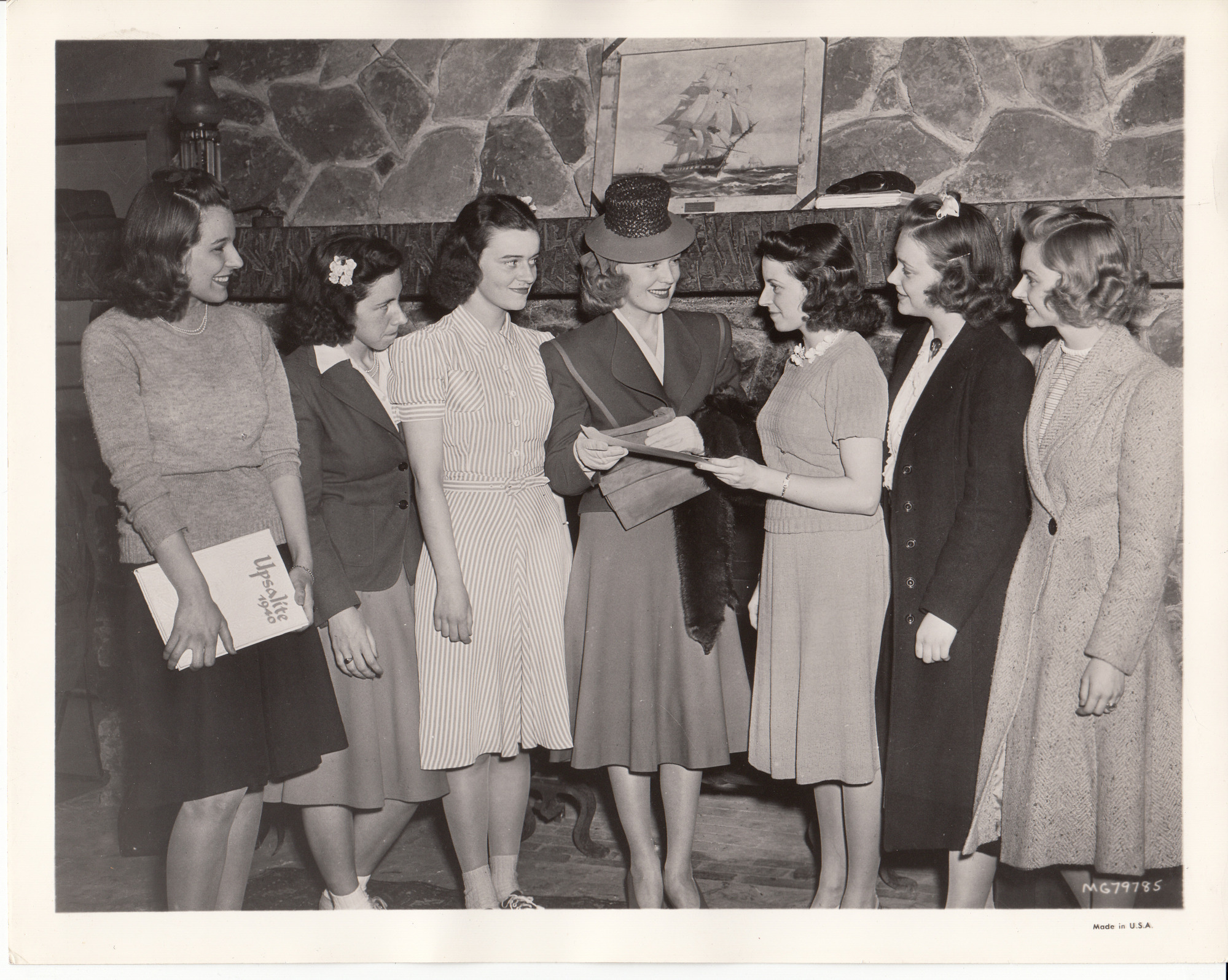 Rita Johnson giving autographs to a group of girls. Yearbook one girl is holding says "Upsalite 1940". The yearbook was from Upsala College in East Orange, New Jersey