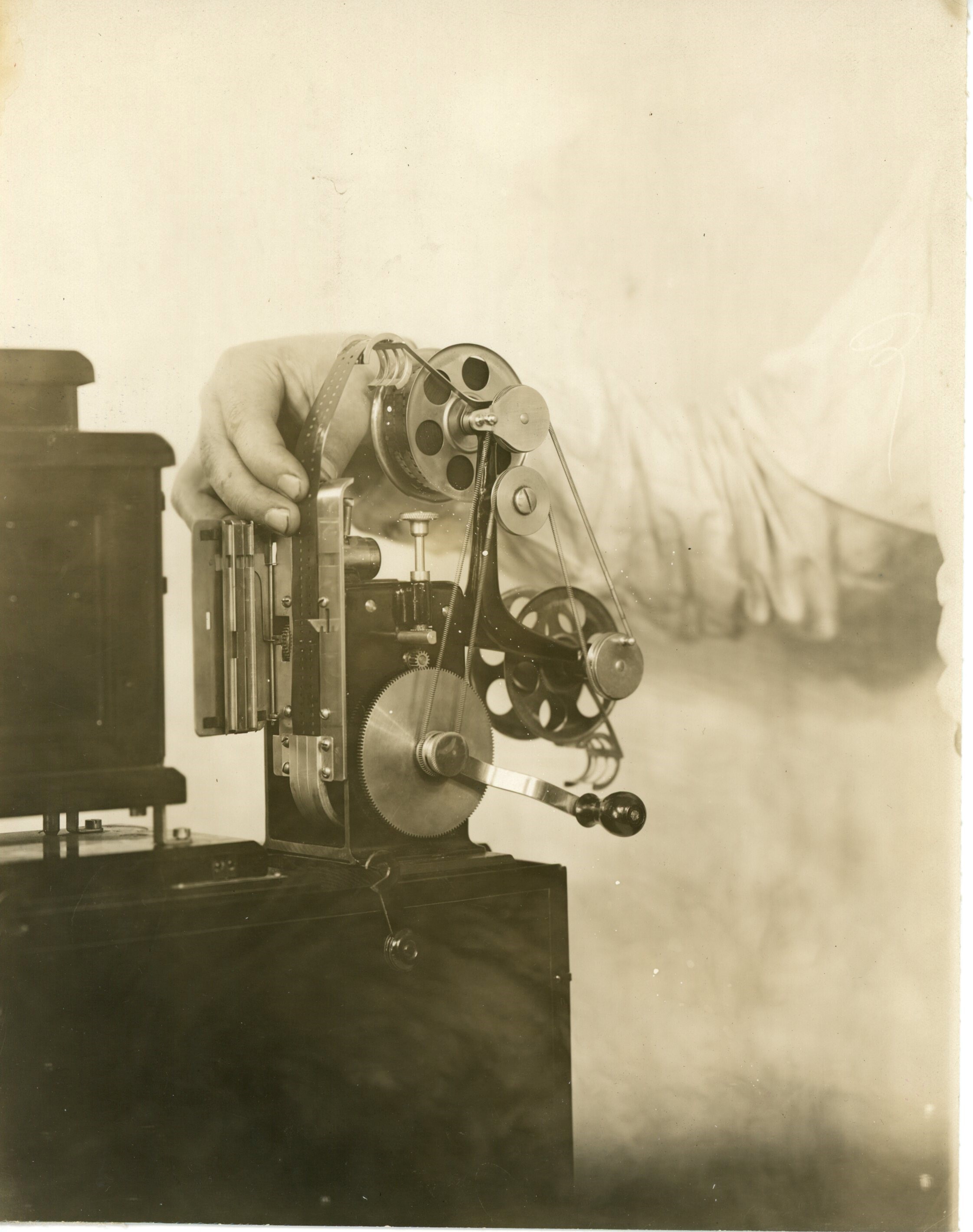 Edison home projecting kinetoscope, hands securing upper reel.