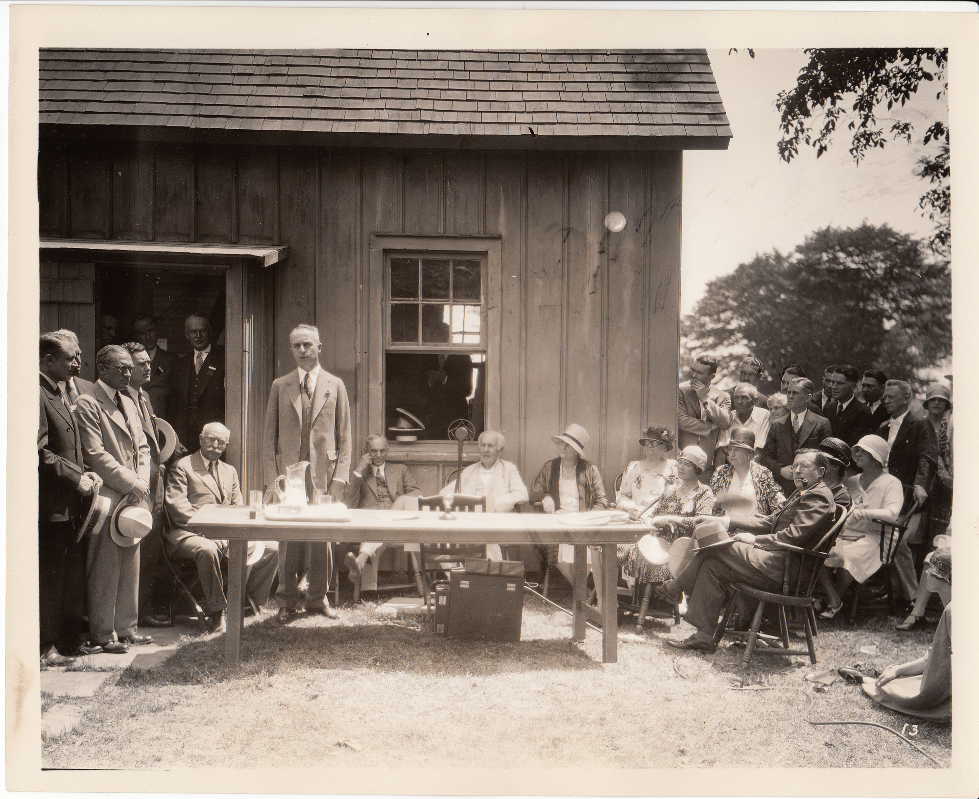 Presentation of Glass House to Henry Ford. Henry Ford, Thomas Edison, Mina Edison, Carolyn Edison are among those seated.