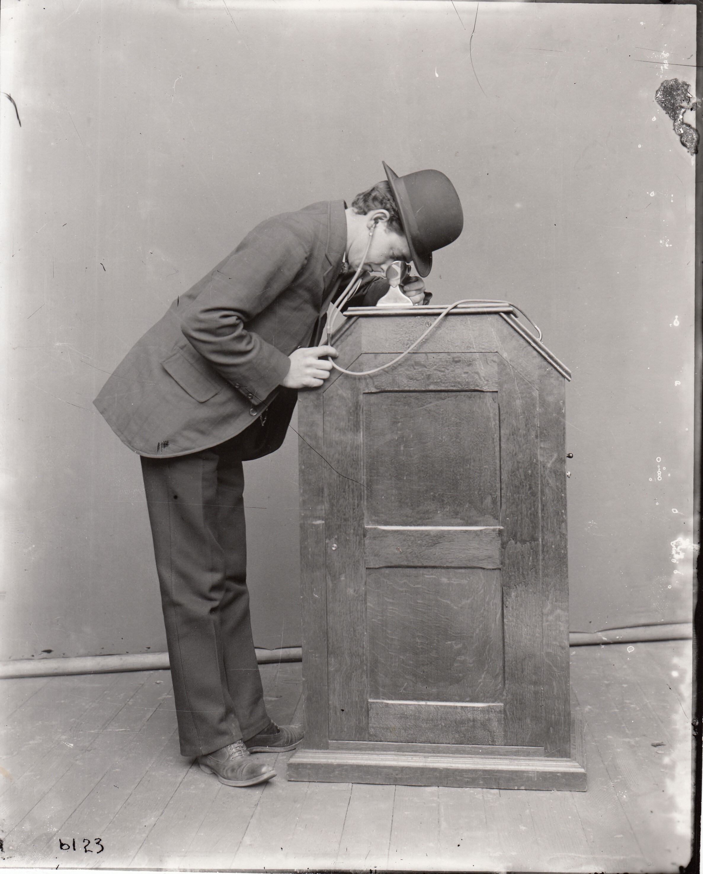 Man viewing a kinetoscope which is equipped with synchronized sound.