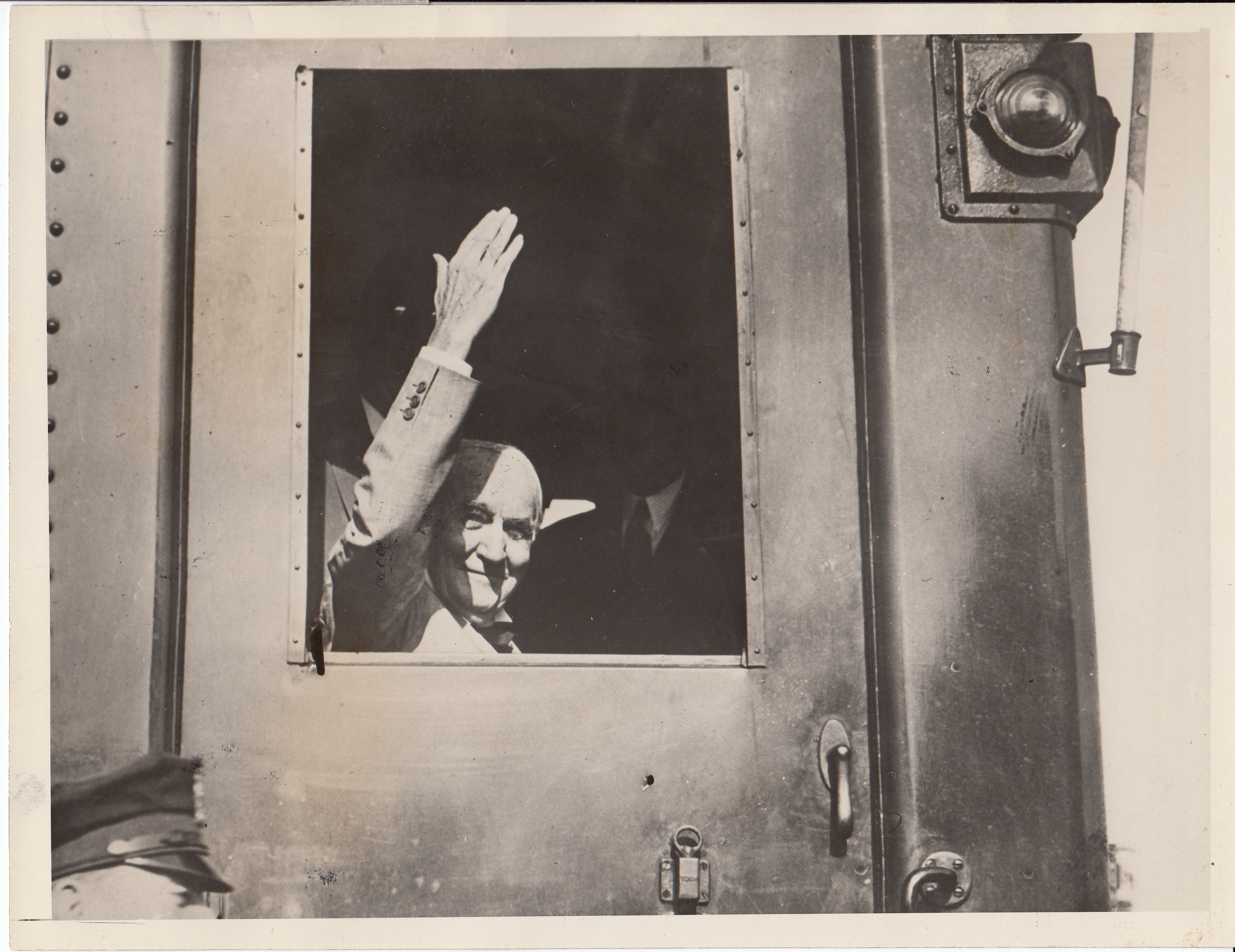 Thomas Edison waving as he drives the first electric train on the Lackawanna Railroad.