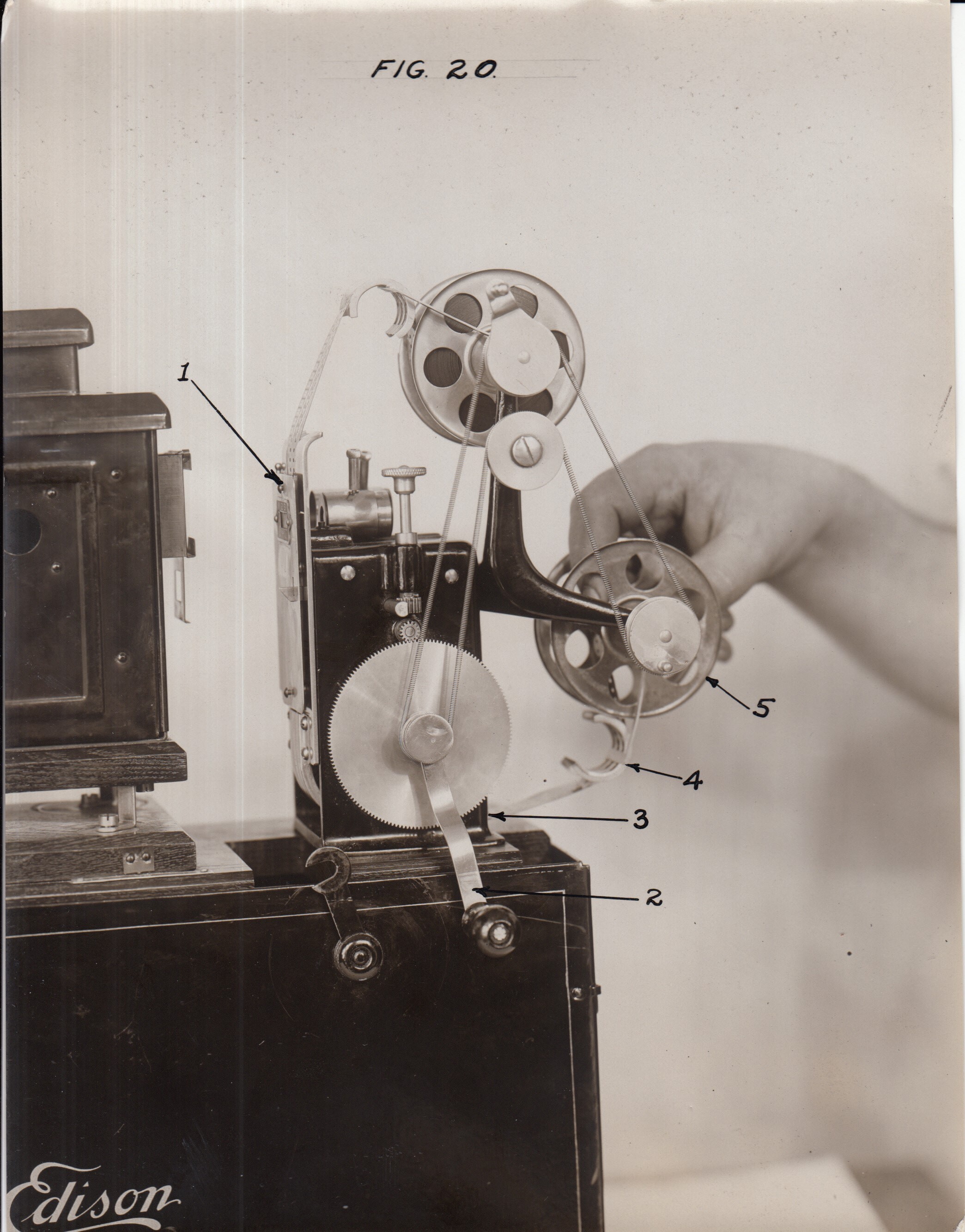 Edison home projecting kinetoscope, reel being wound by hand.