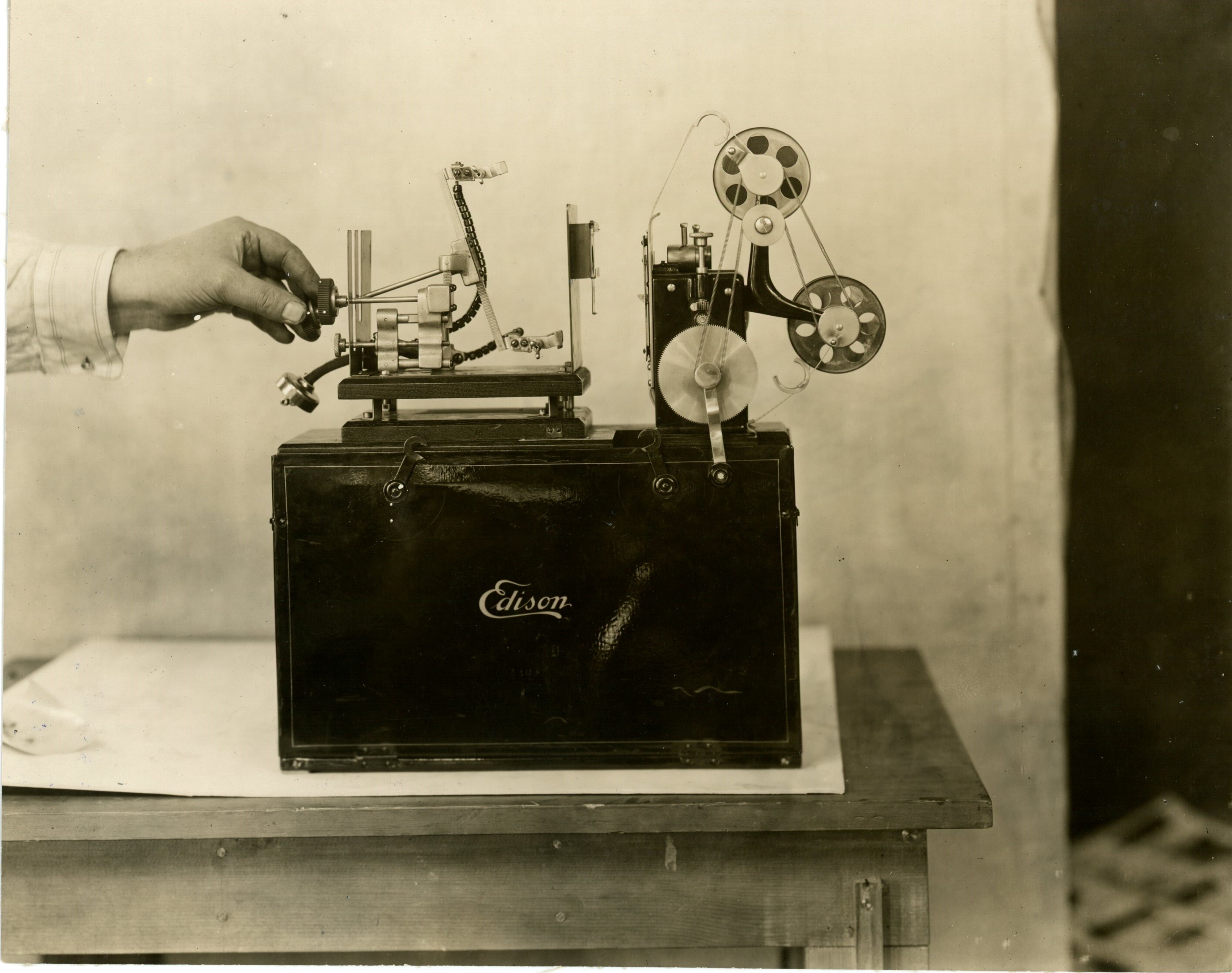 Edison home projecting kinetoscope, hand opening lamp arms.