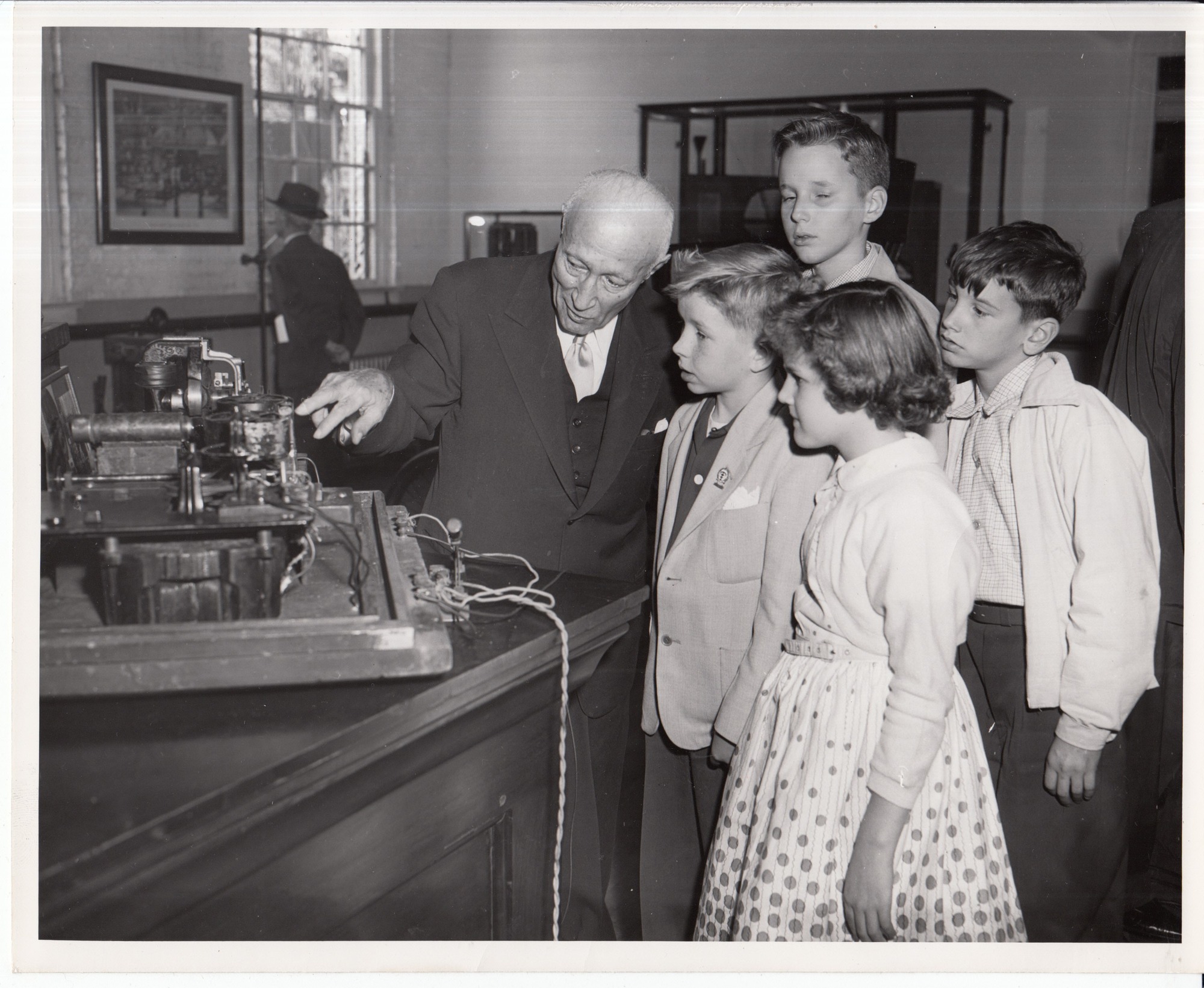 Adolph Zukor, Paramount Pictures Corp., showing 1889 strip kinetograph to West Orange school children during dedication ceremonies of Black Maria replica.