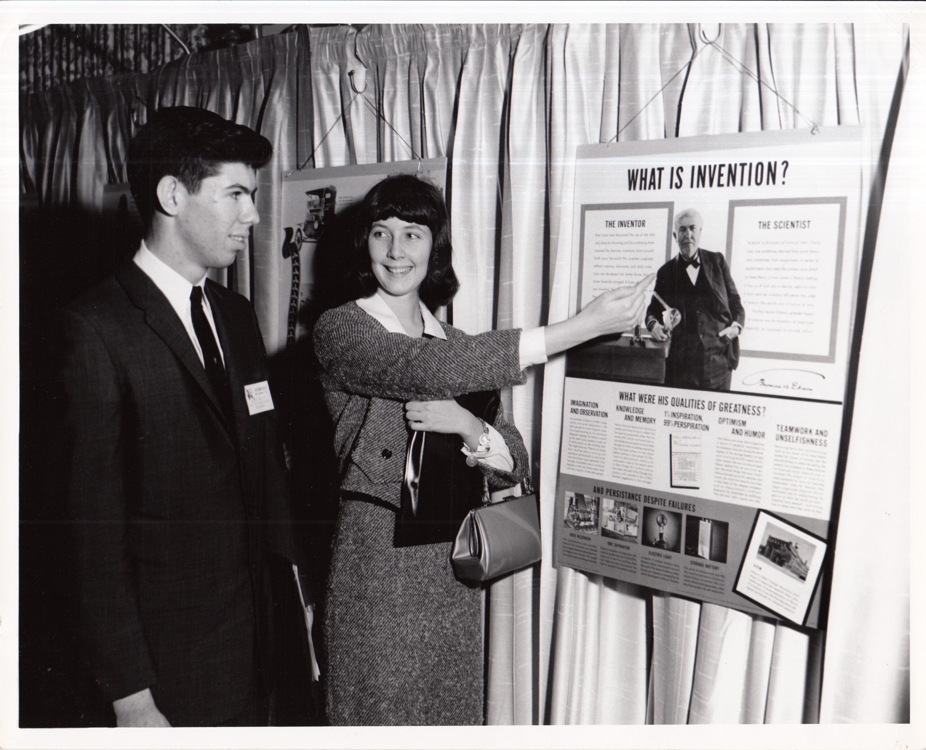 Visitors looking at poster, "What Is Invention," at unidentified exhibition.