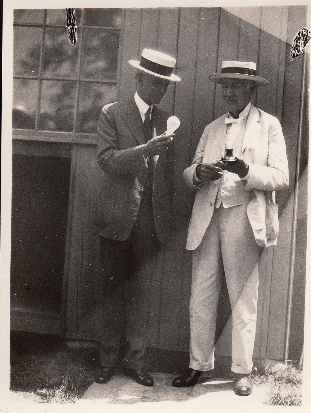 Thomas Edison and Henry Ford holding incandescent lamps at presentation of Glass House to Henry Ford.
