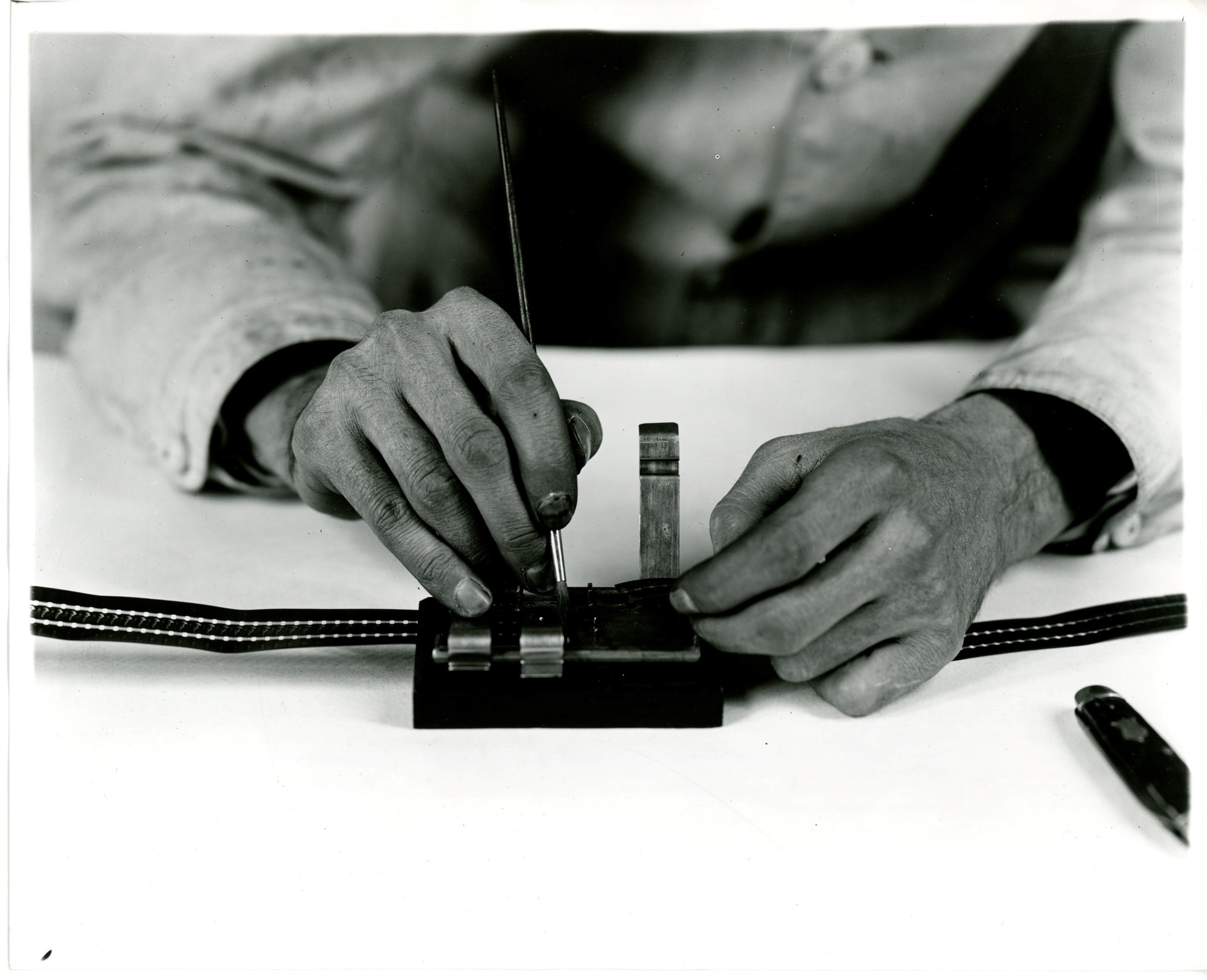 Edison home projecting kinetoscope, man using film mender.