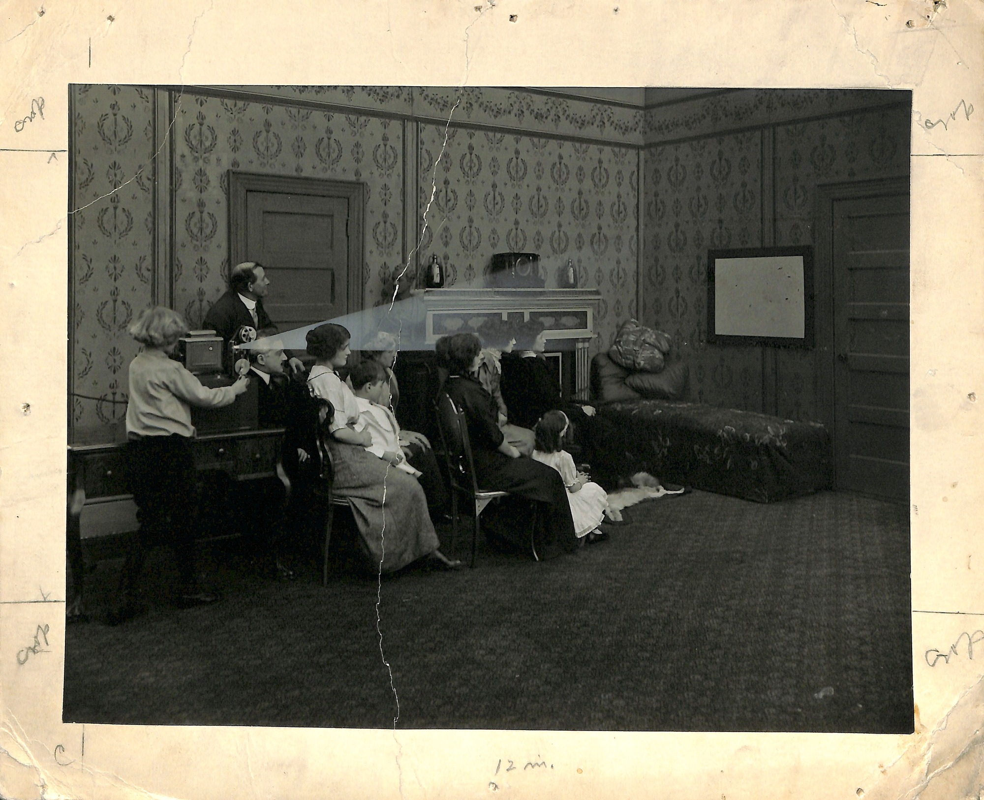 Home projecting kinetoscope advertising picture, made at Edison's studio about 1912, family watching film in living room.