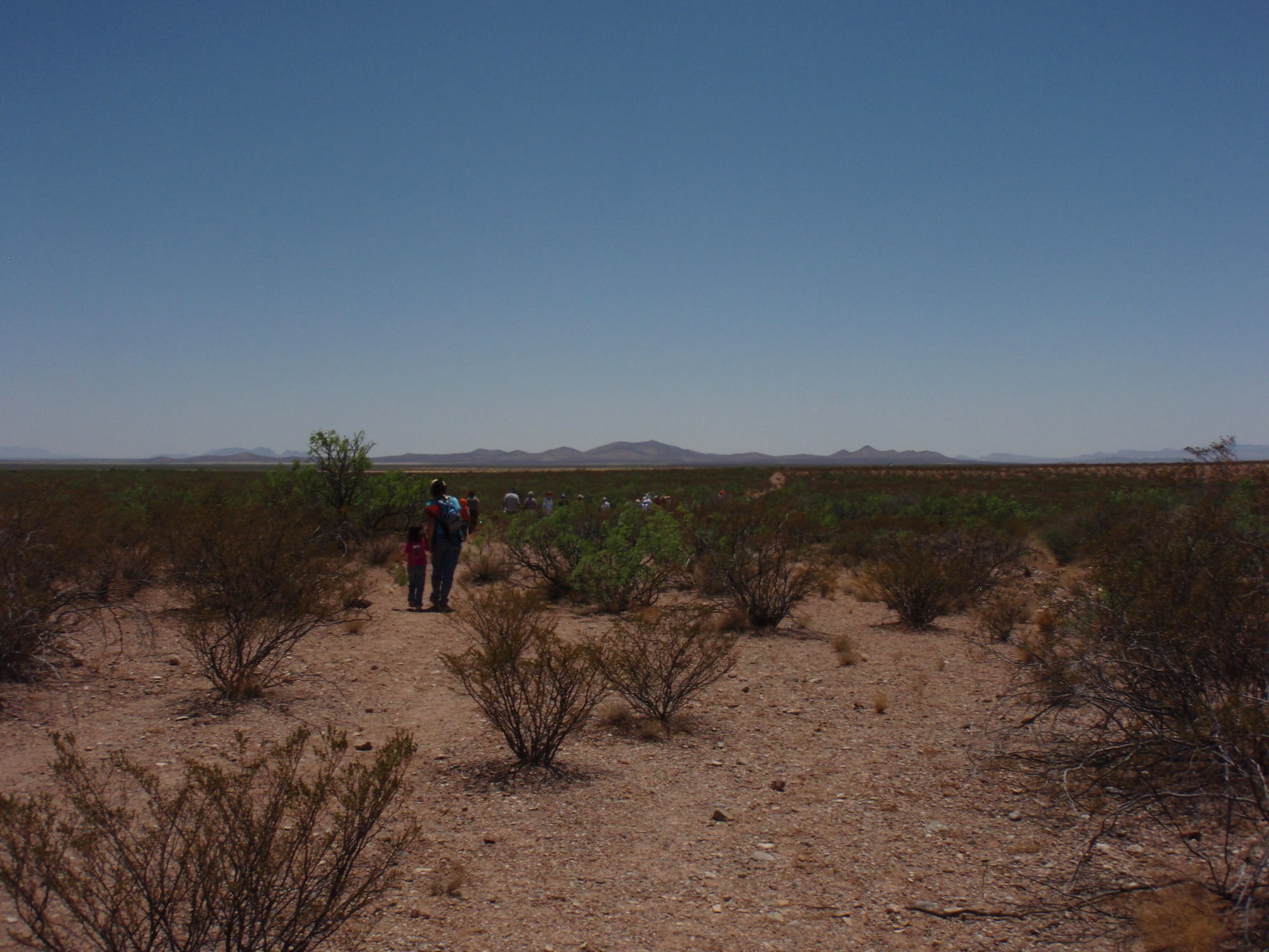 A group of people walking down a dirt path.