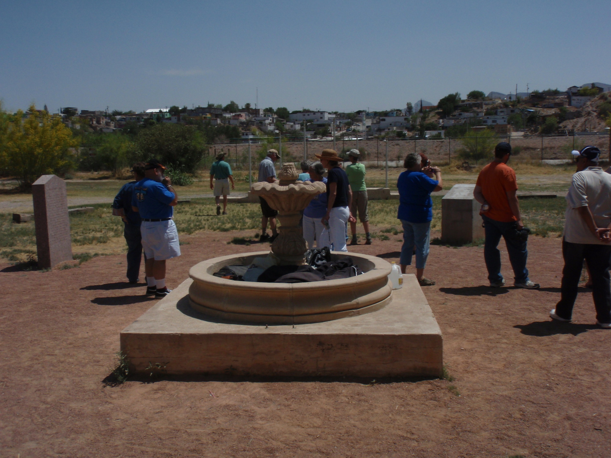 A group of people standing around a fountain.