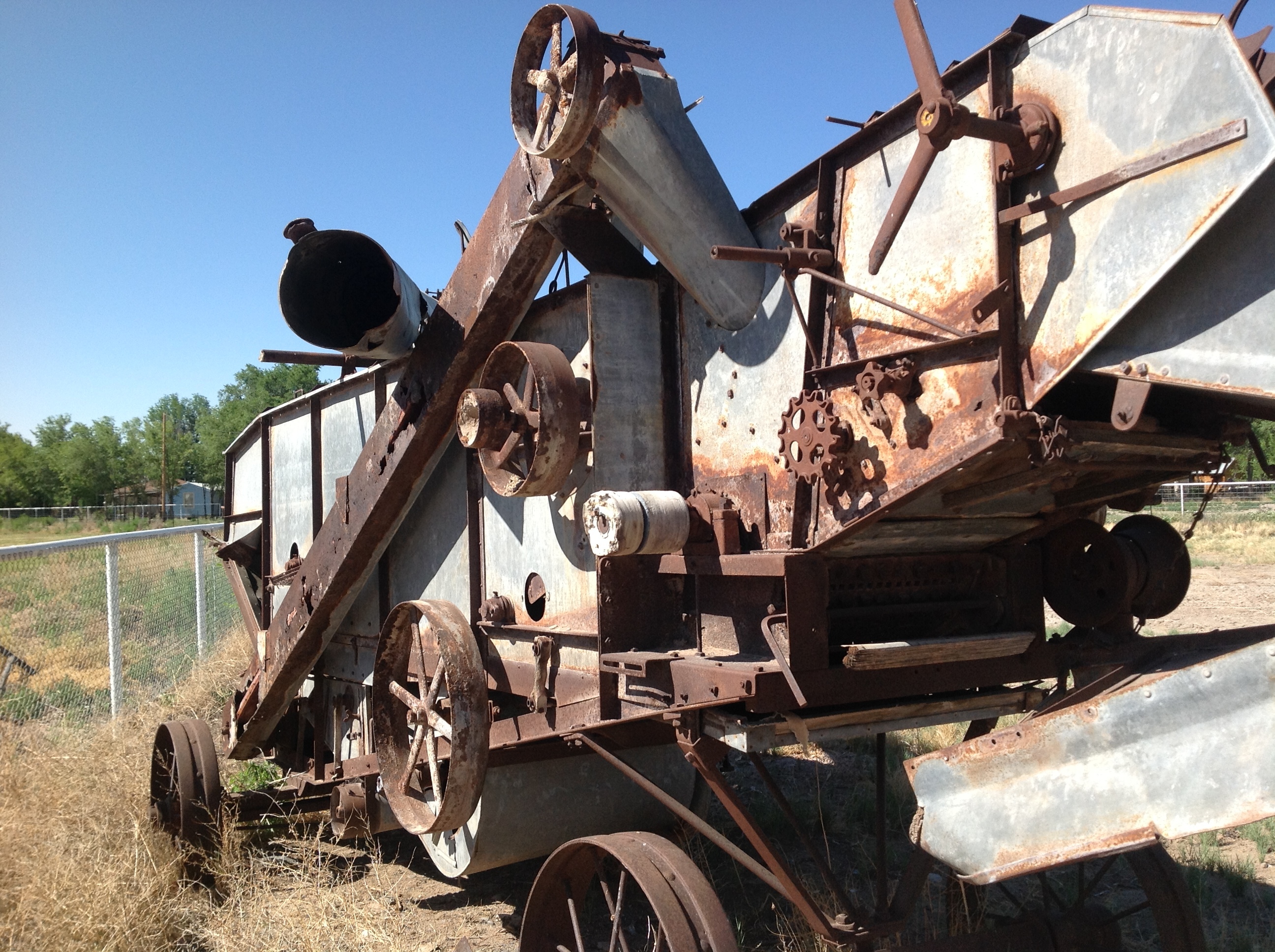 An old rusty machine sitting in a field.