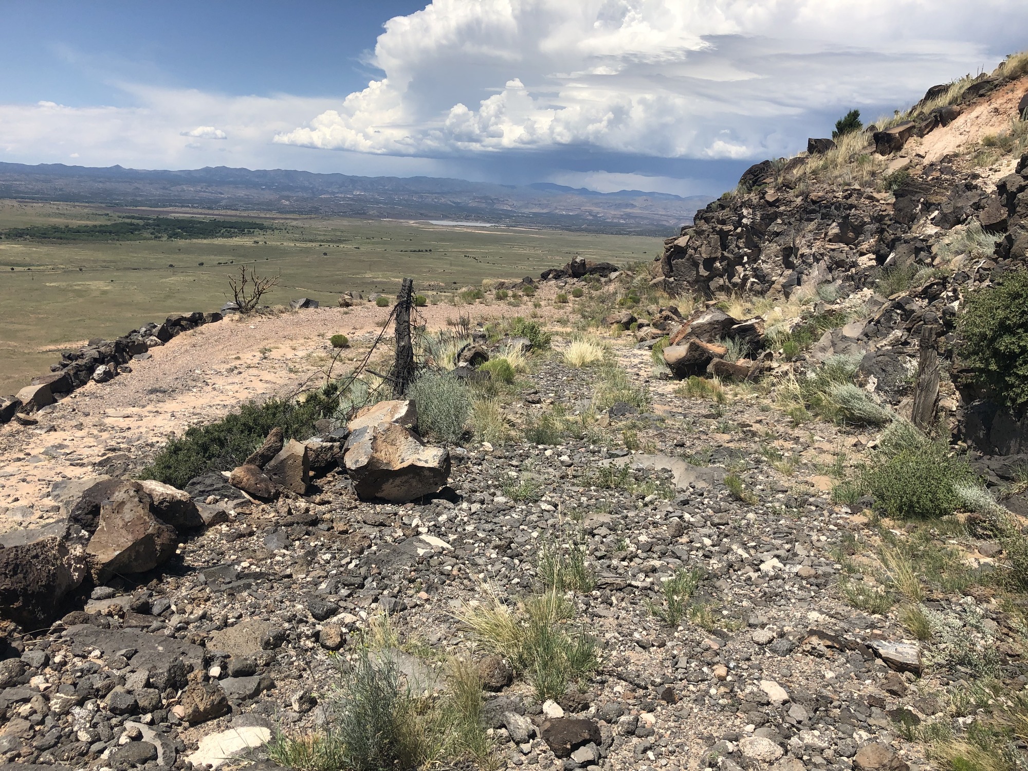 A view of a rocky hillside with a cloudy sky.