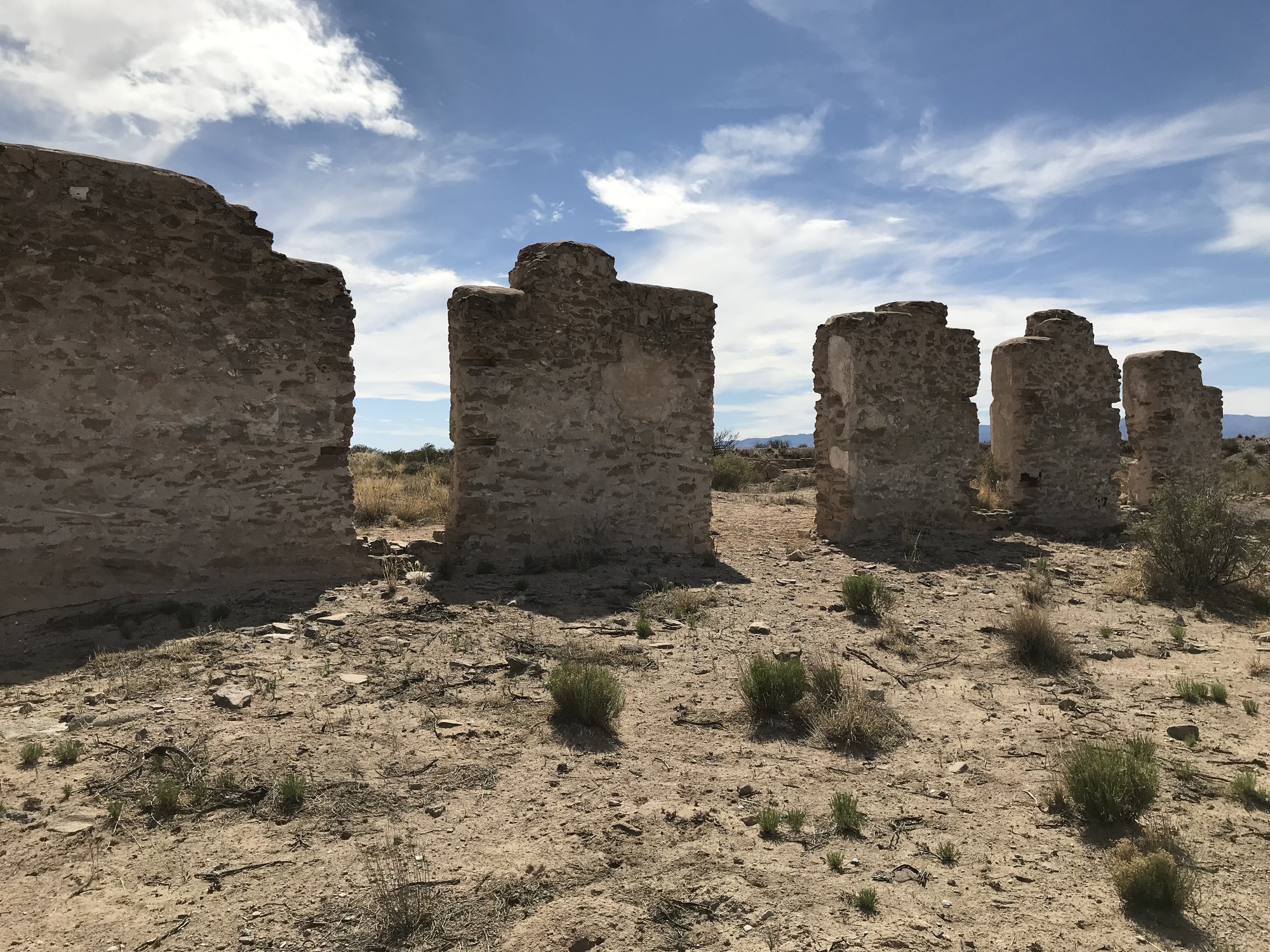 Some ruins in the desert with a blue sky.