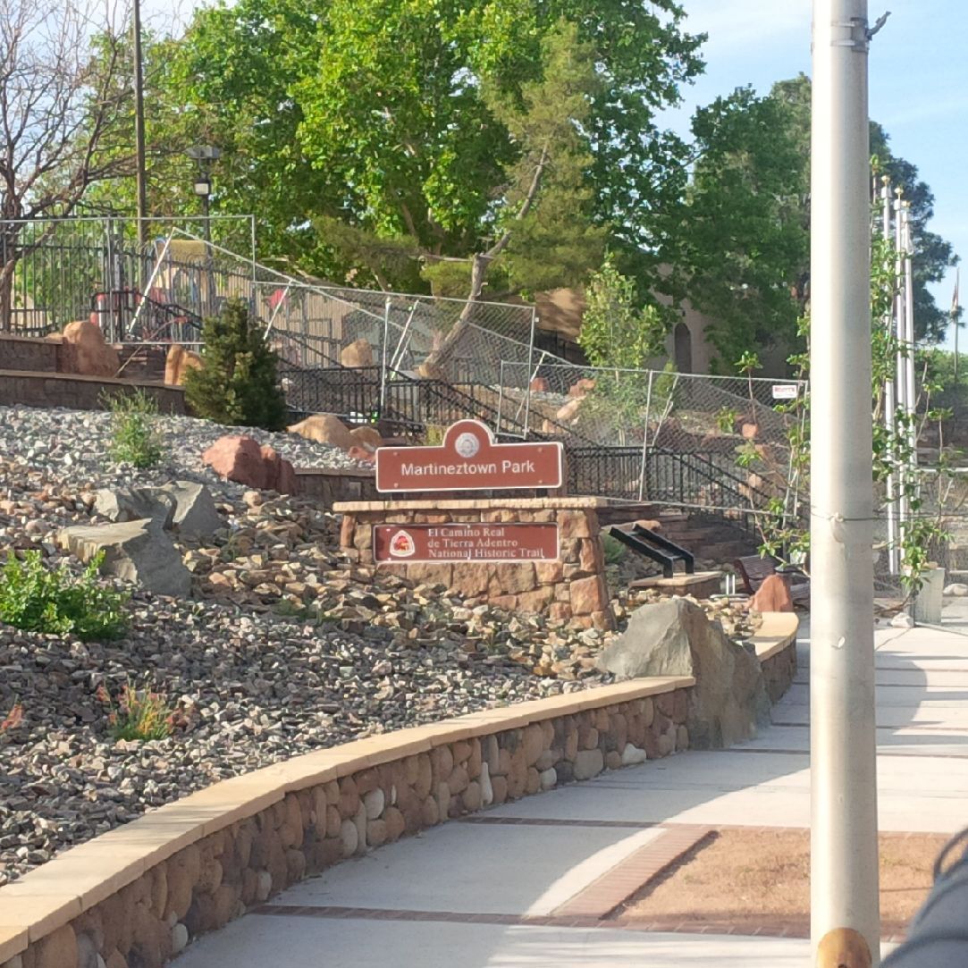 The entrance to a park with rocks and a sign.