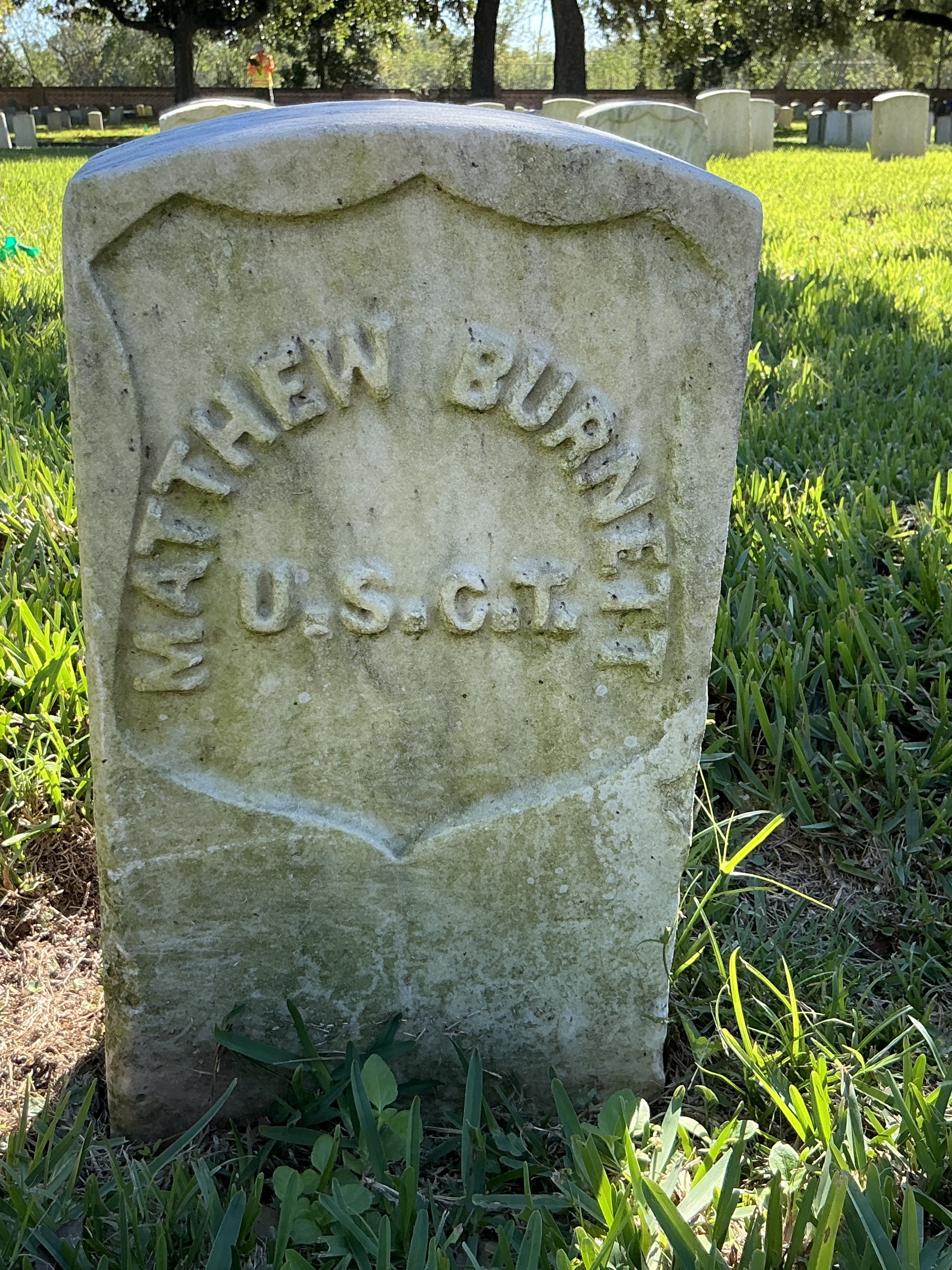 Back of historic upright marble headstone with recessed shield face.