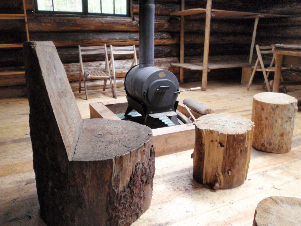 Log furniture and wood stove inside a cabin.
