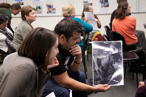 A man and a woman look at a black and white photograph