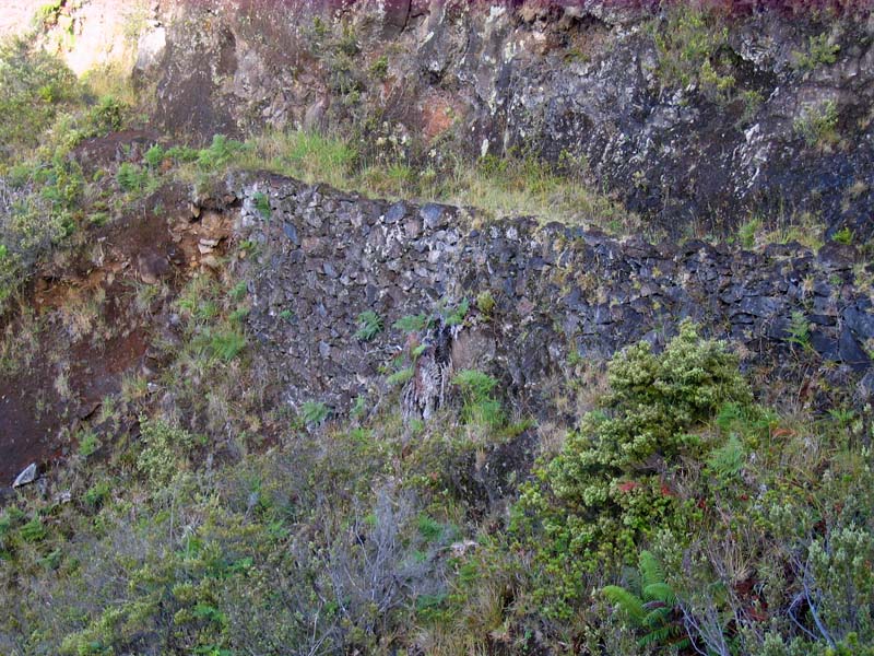 The hiking trail is barely visible as it curves along the natural contours of a rocky hillside.
