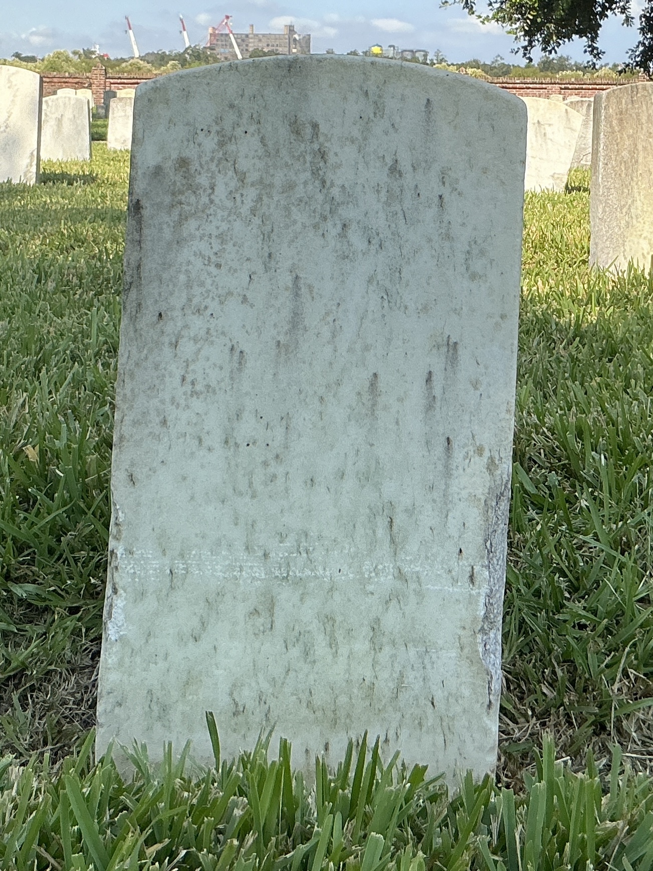 Back of historic upright marble headstone with recessed shield with recessed lettering face.