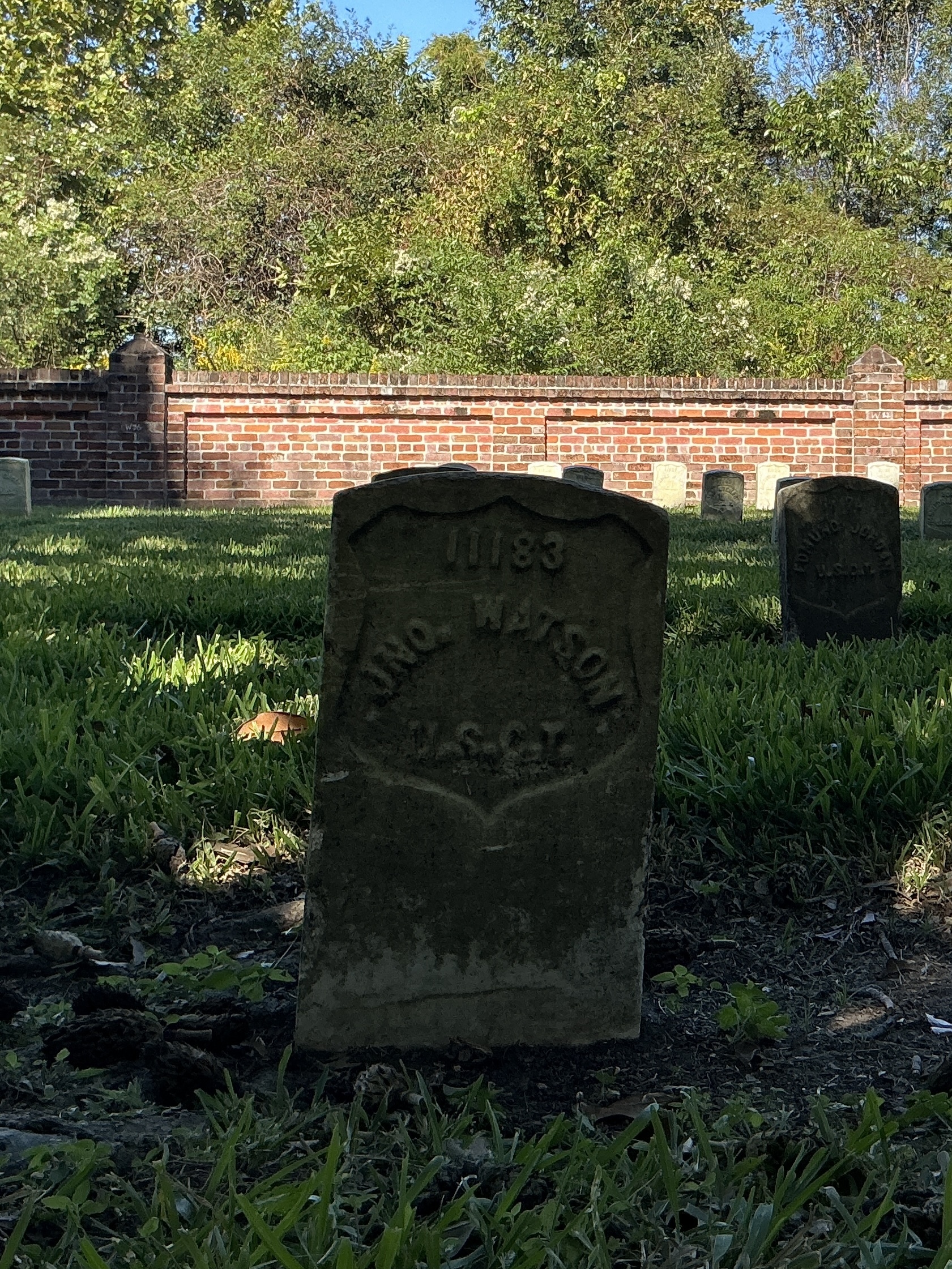 Front of historic upright marble headstone with recessed shield face.