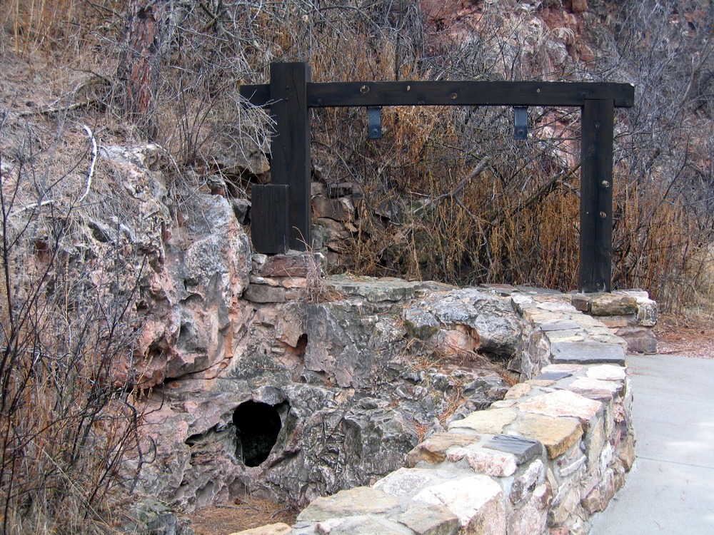 a small hole in the rock next to the sidewalk