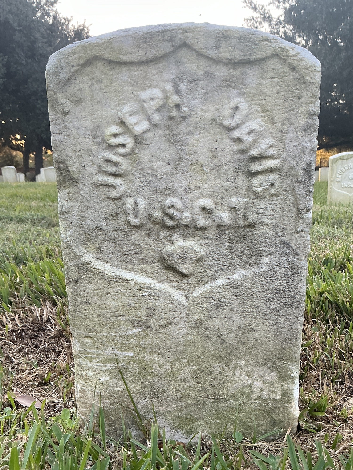 Back of historic upright marble headstone with recessed shield face.