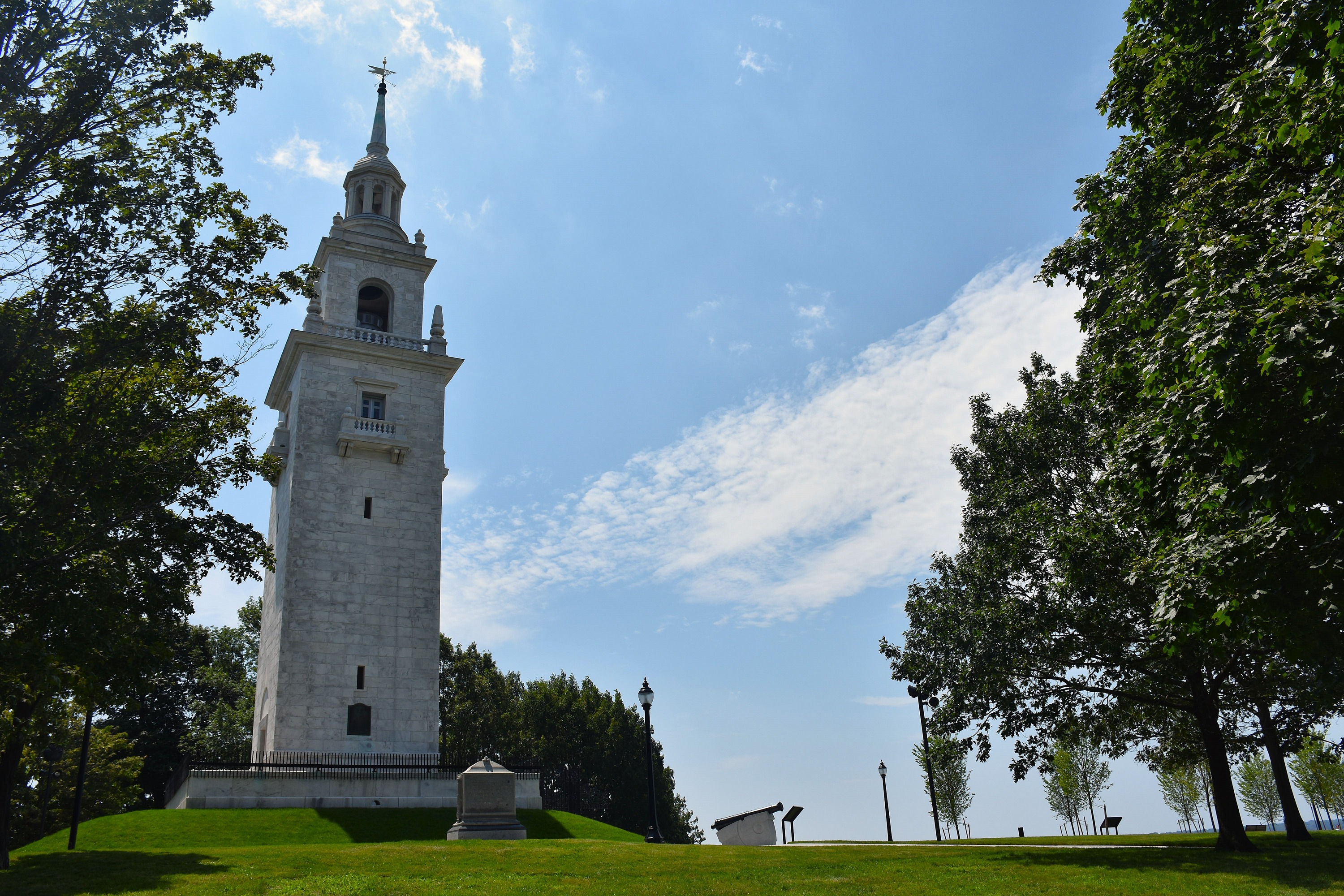 Dorchester Heights Monument, a white granite stepped tower surrounded by trees and grass.