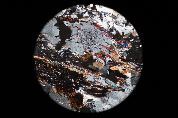 Circular microscopic image of rock structure.