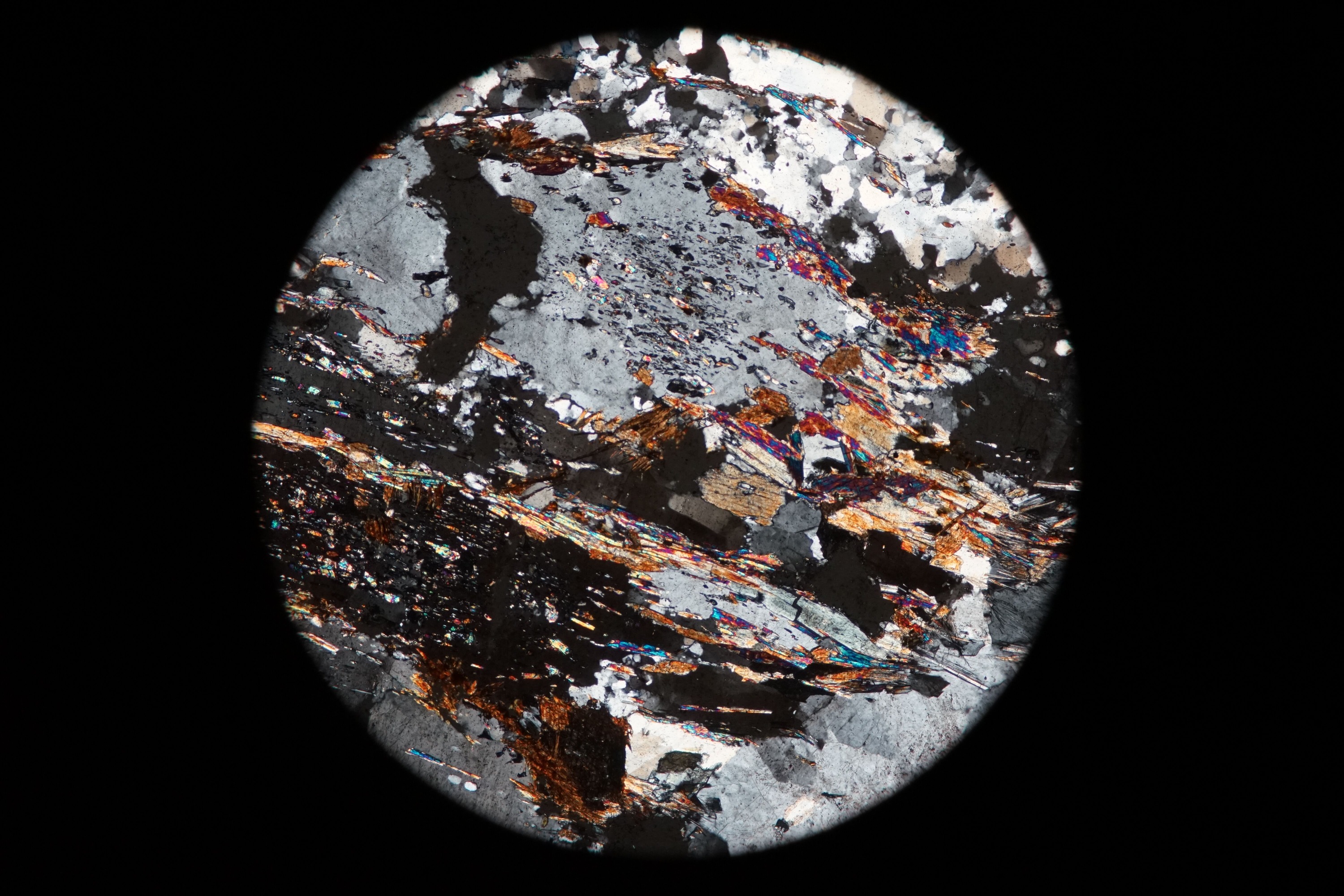 Circular microscopic image of rock structure.