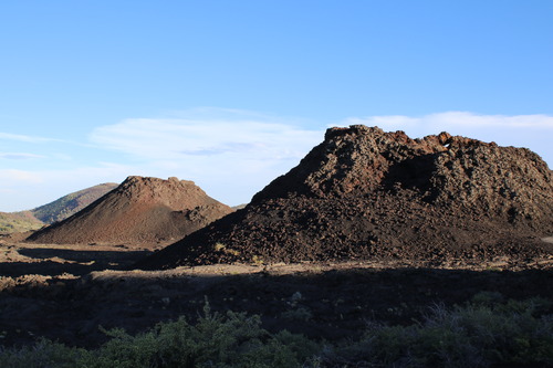 two smaller volcanoes and one large cinder cone in the distance