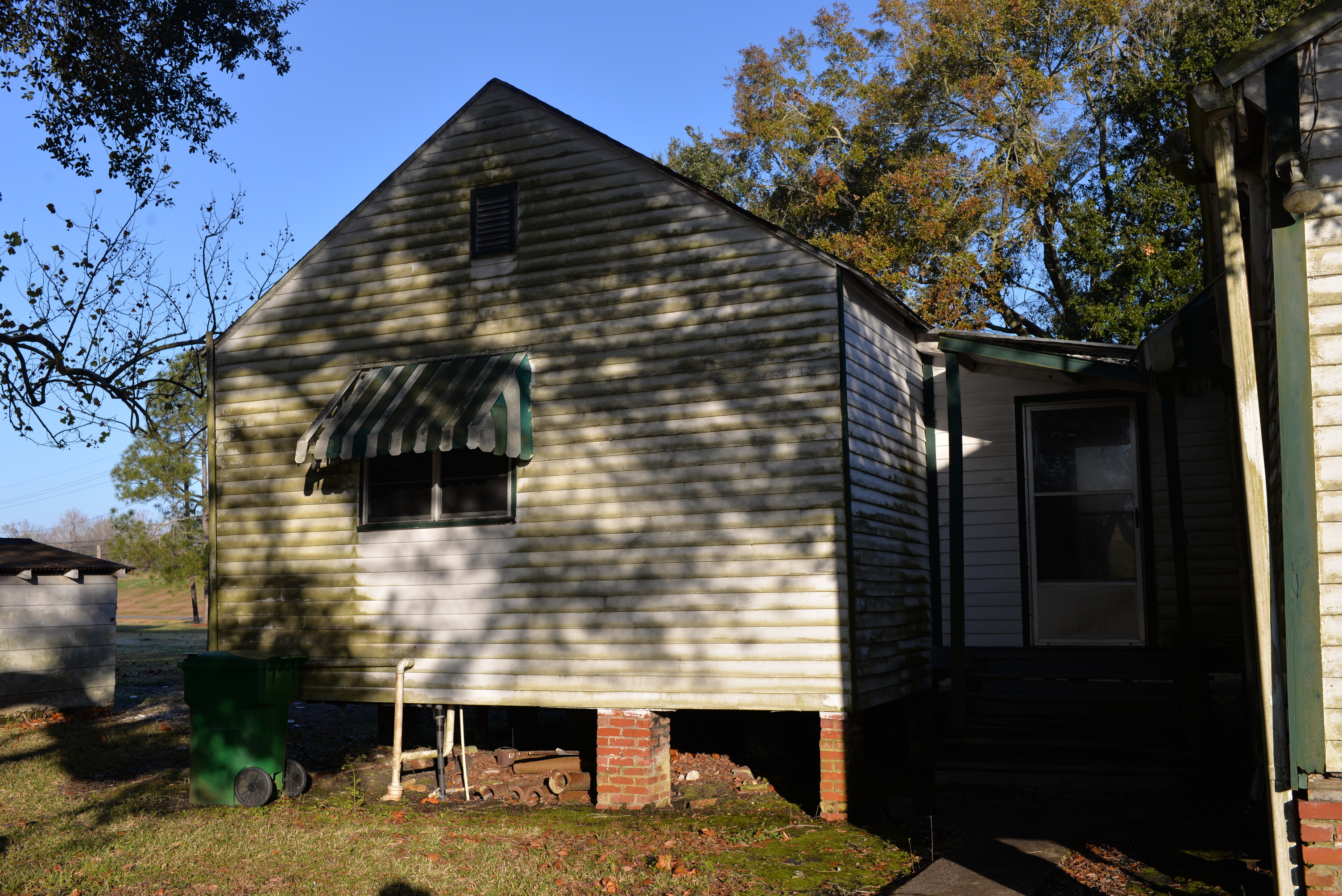 White sided structure with green accents.