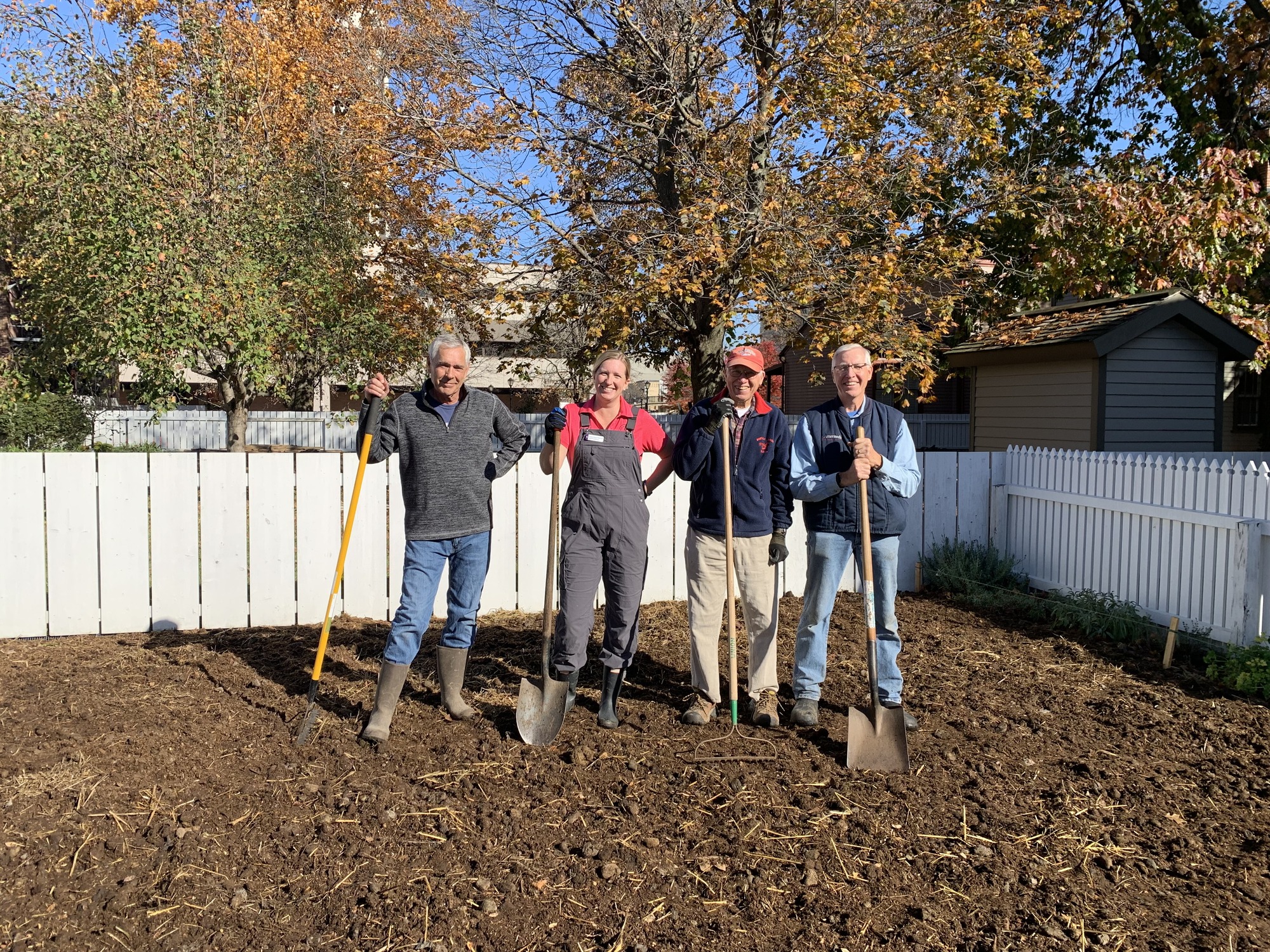 A group of volunteers from the University of Illinois Extension Master Gardener program standing in a garden with shovels.