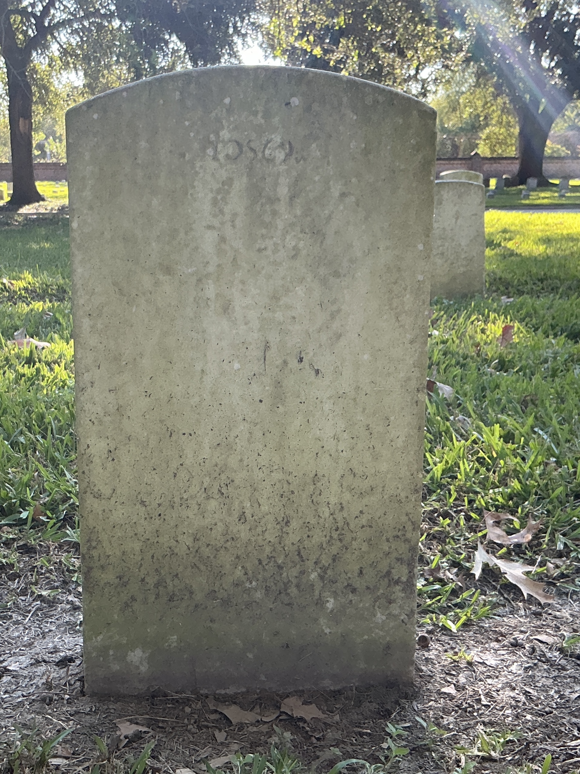 Back of upright marble headstone with flat face.