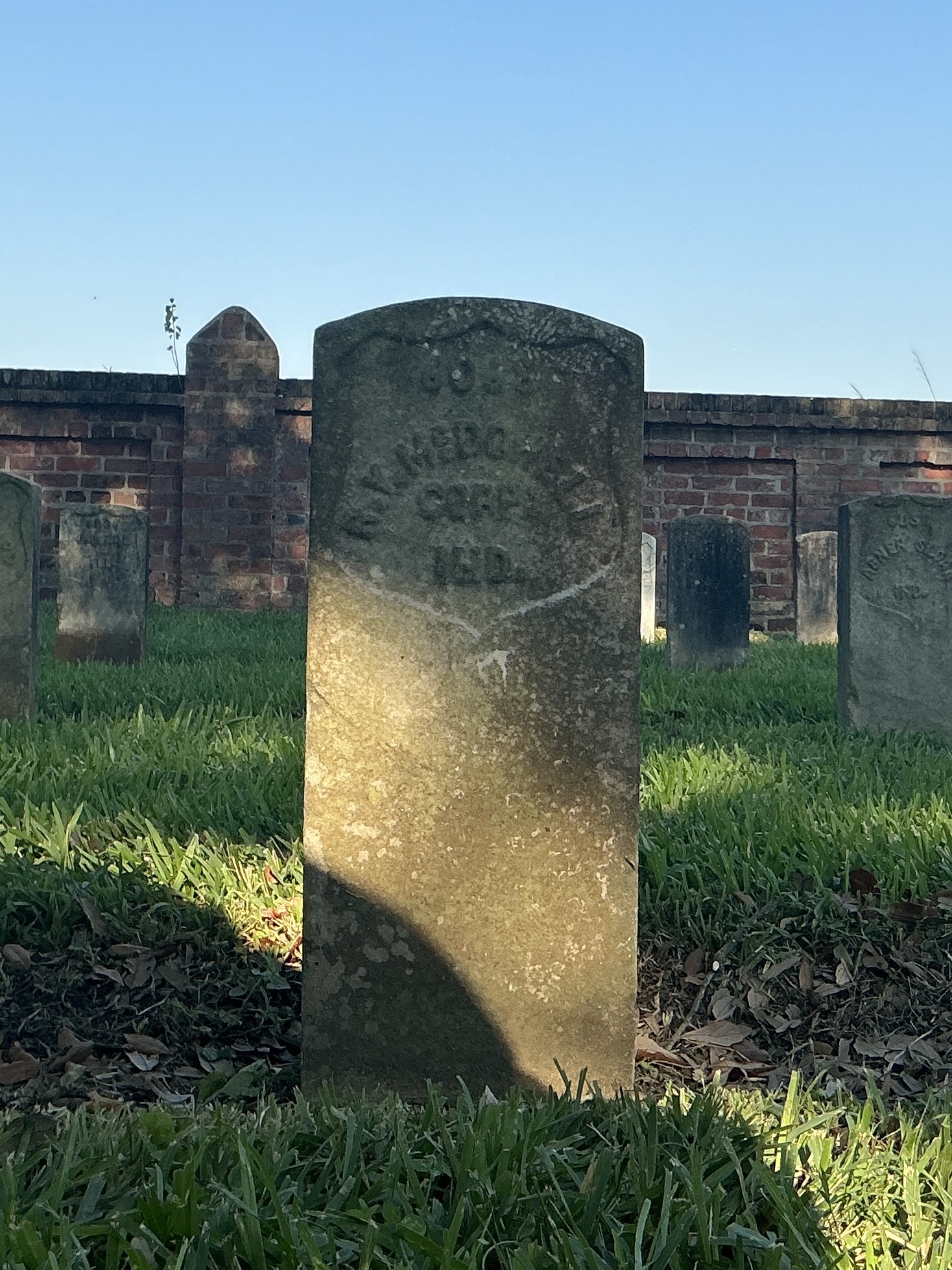 Front of historic upright marble headstone with recessed shield face.
