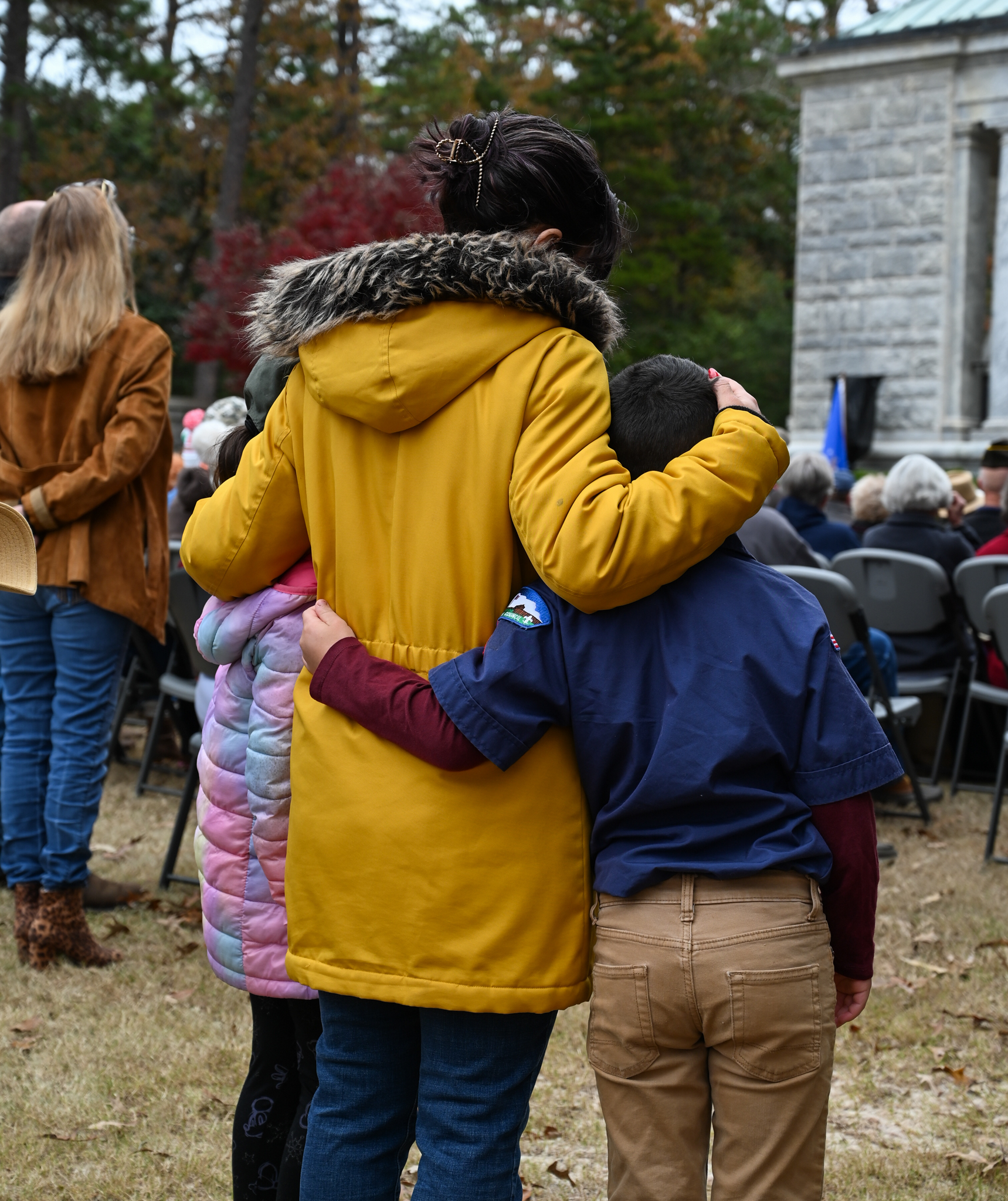 Young family hugging during the ceremony.