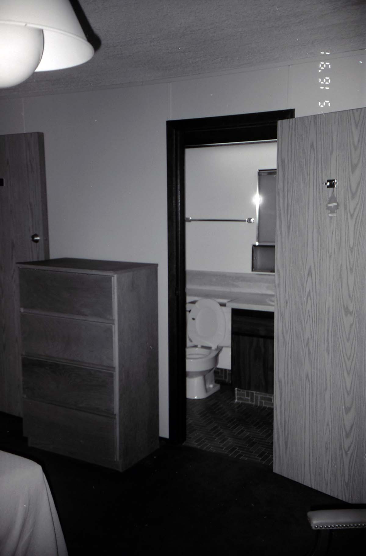 Bedroom and bathroom in barracks. [Image possibly for comparative housing study]