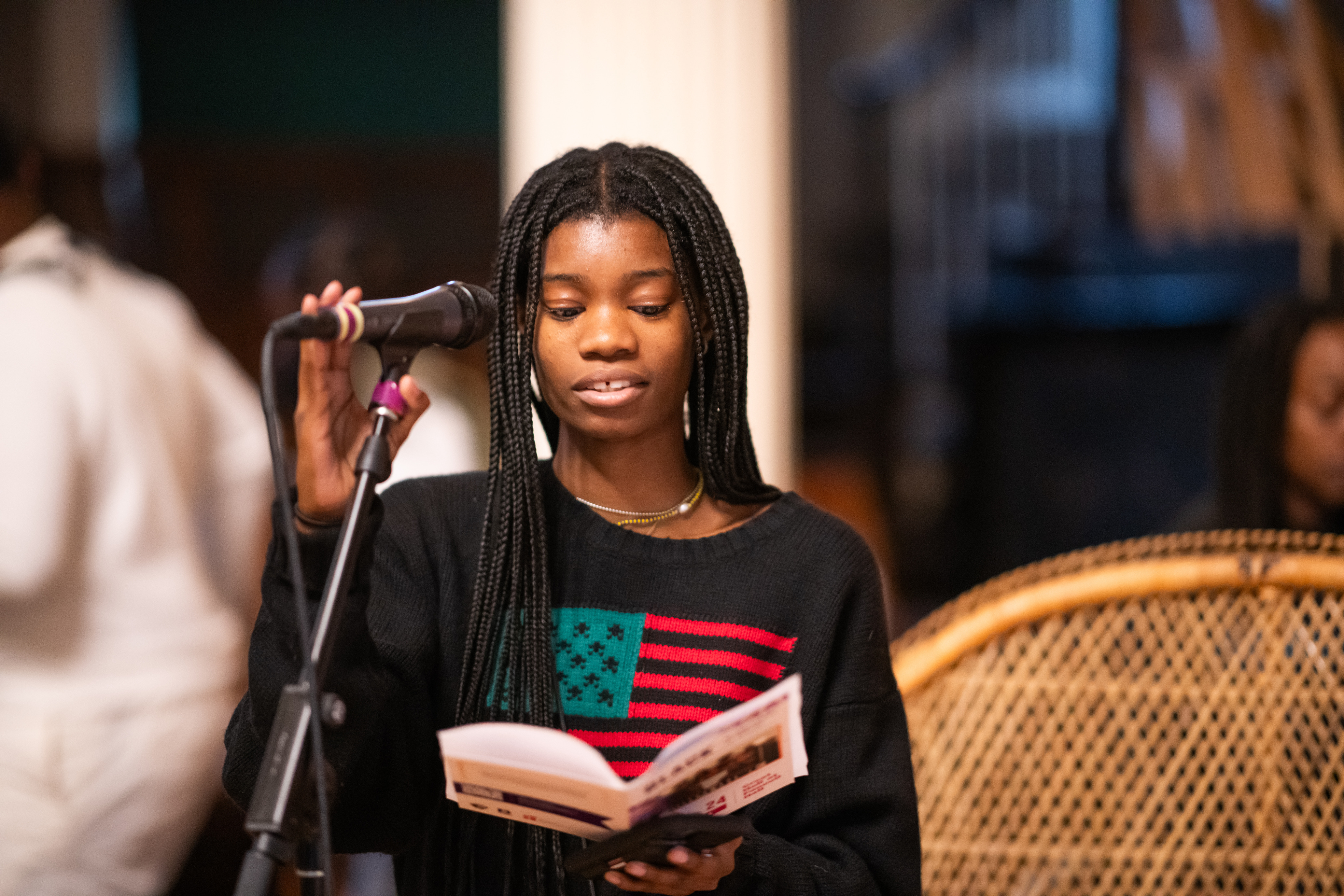 Cierra Peters standing at a microphone and reading from a piece of paper. 