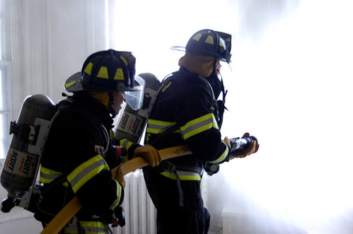 two structural fire fighters with powerful fire hose