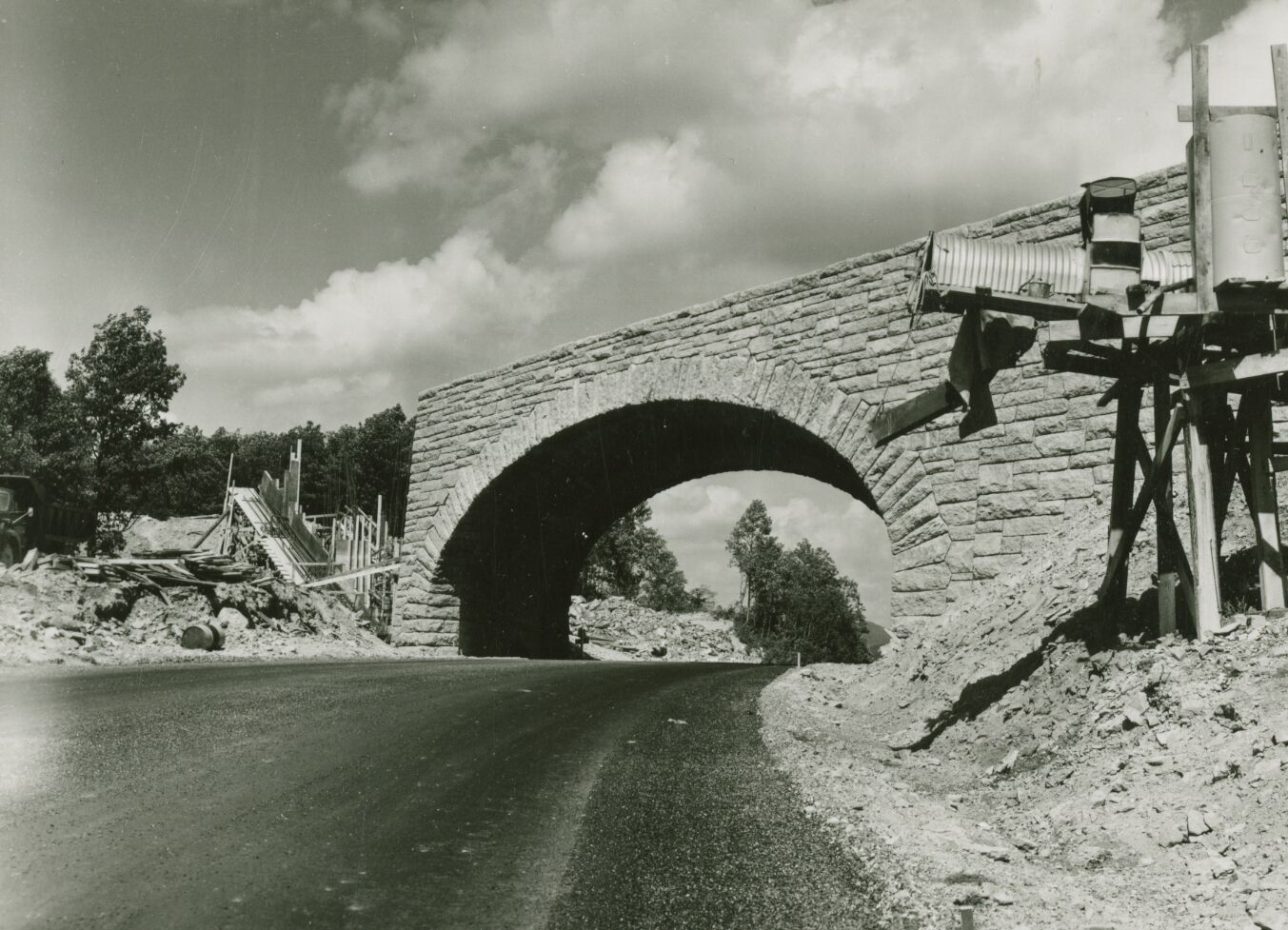 Construction site with stone bridge crossing over a roadway