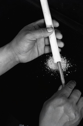 Chief Lemee hollowing out stick for flute.