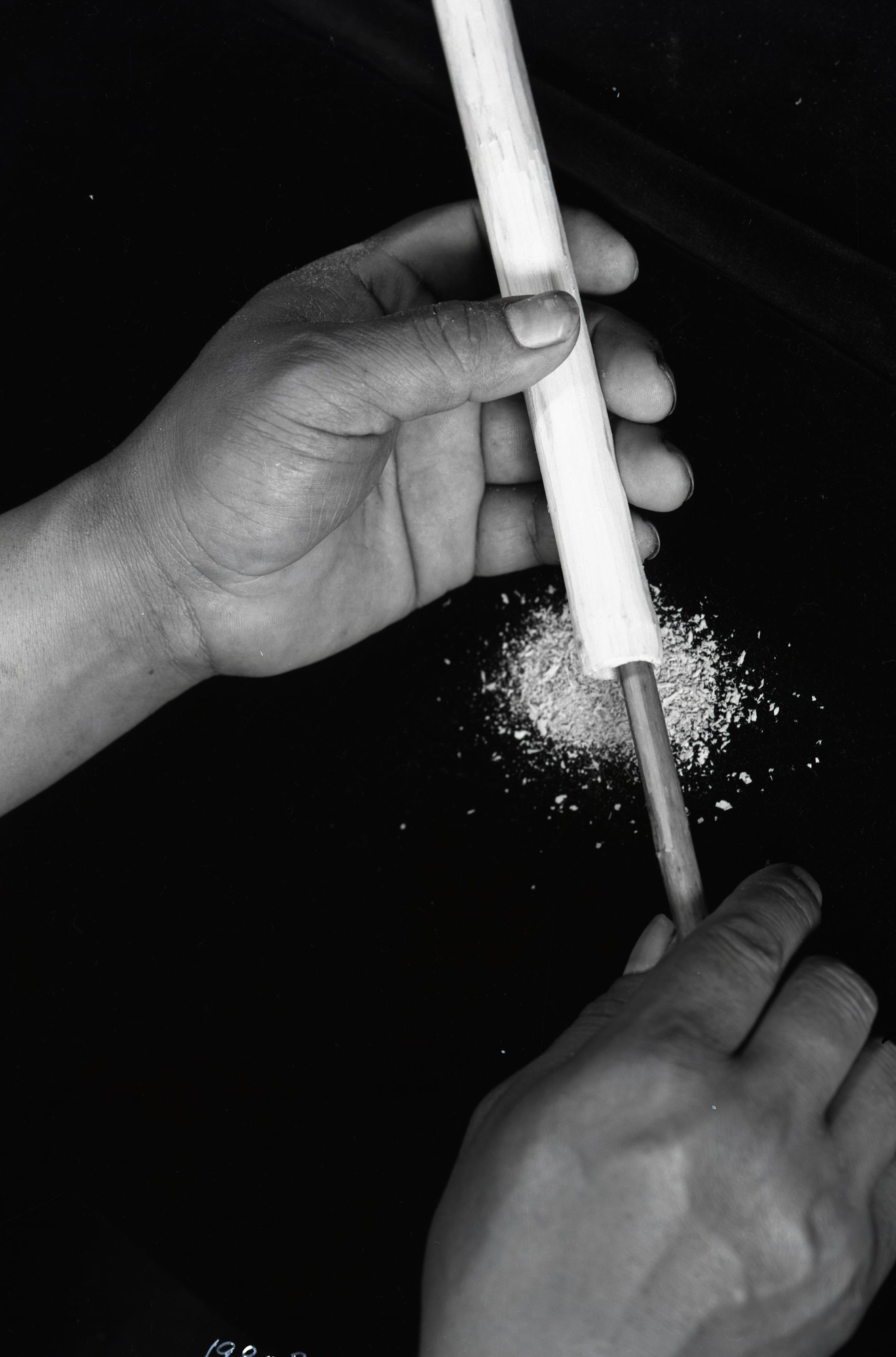 Chief Lemee hollowing out stick for flute.