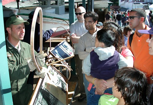A park employee explains to visitors how oak can be bent into a circle using steam.