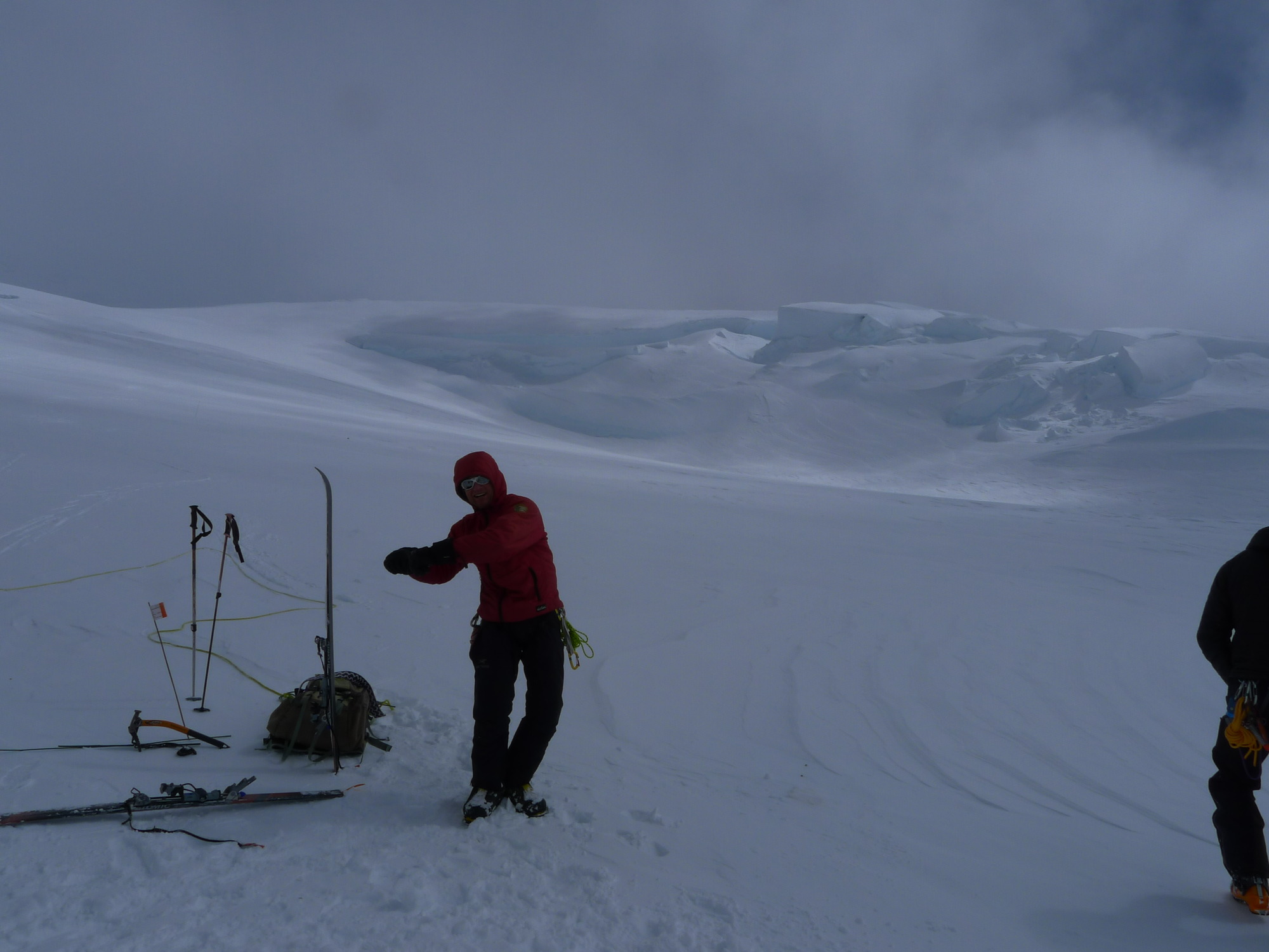 two people with skis standing on a snowy mountainside