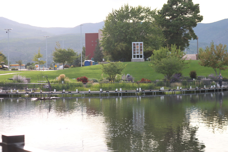 Luminarias line the edge of a city pond.
