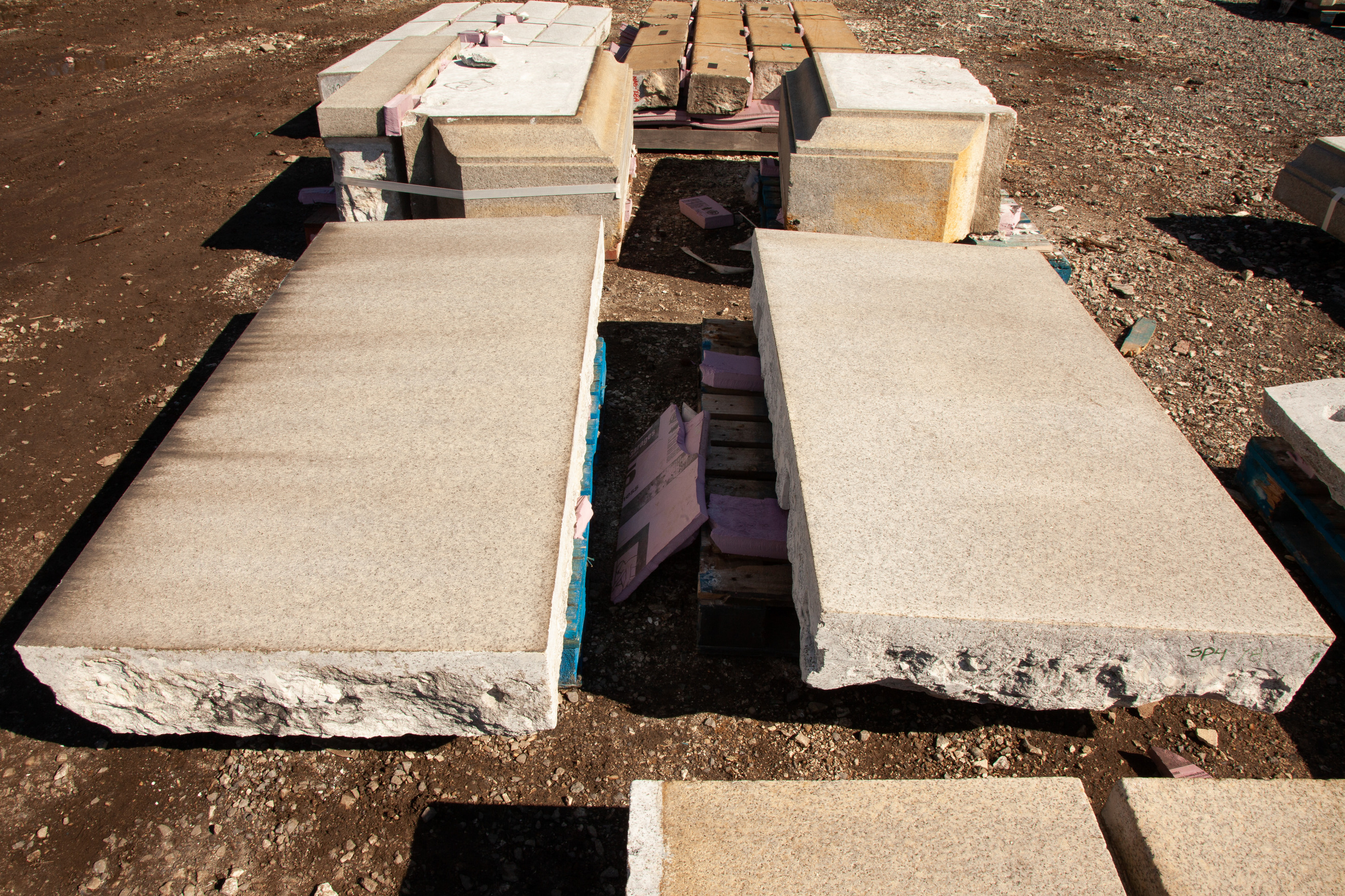 Two large slabs of granite, the piece on the right is restored and cleaned.  The piece on the left has dirt marks still on it. 