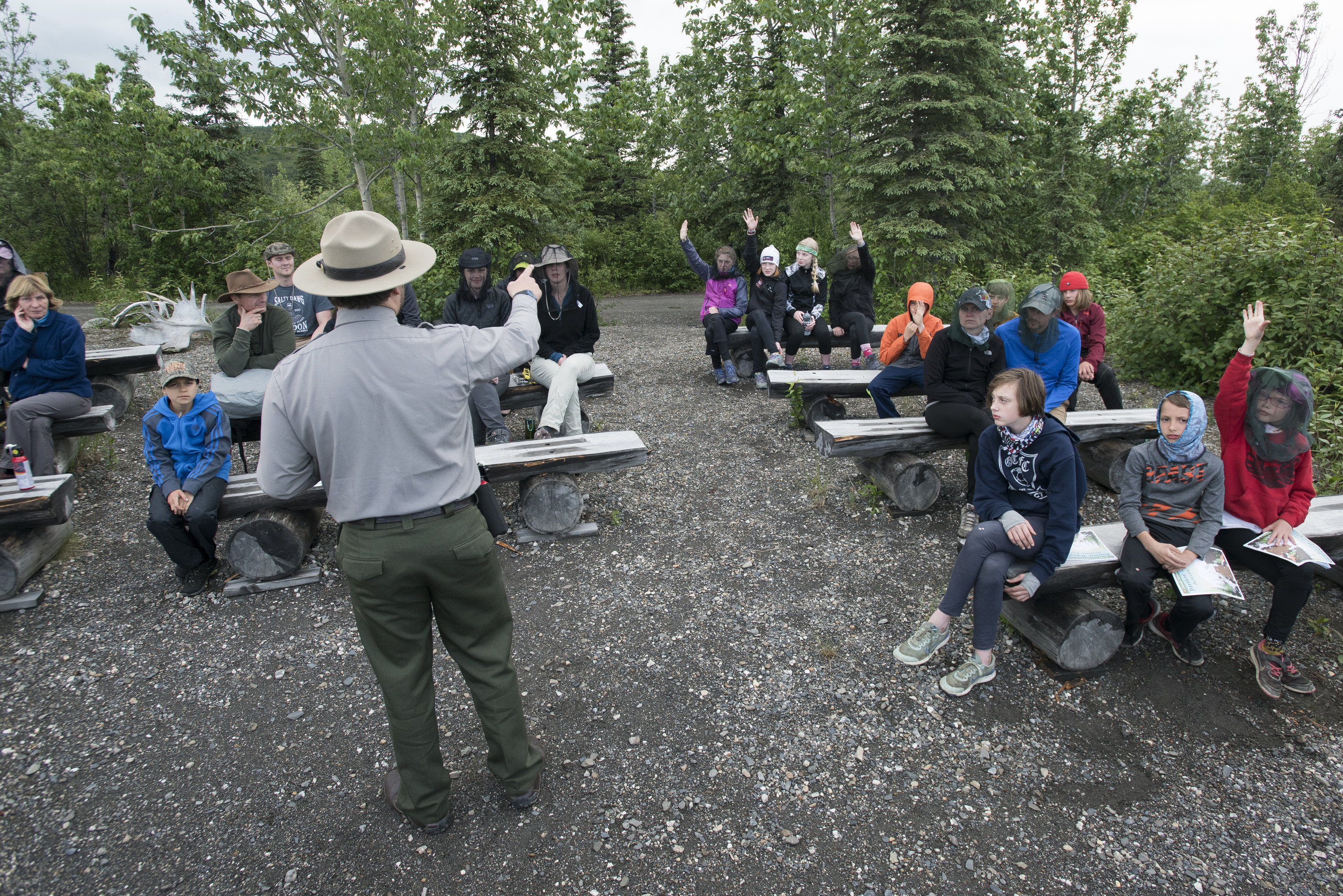 a ranger speaking to people seated at an outdoor amphitheater